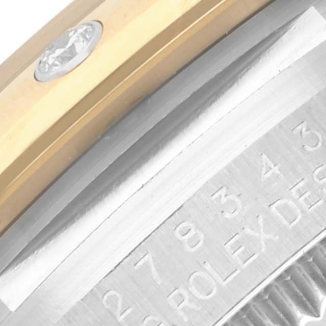 The image shows a close-up of the side of a Rolex Mid-Size 278343RBR-0032 Women's Steel and Gold (two tone) Green Dial 278343RBR-0032 Women's Steel and Gold (two tone) Green Dial watch, highlighting the bezel with a diamond and engraved details.