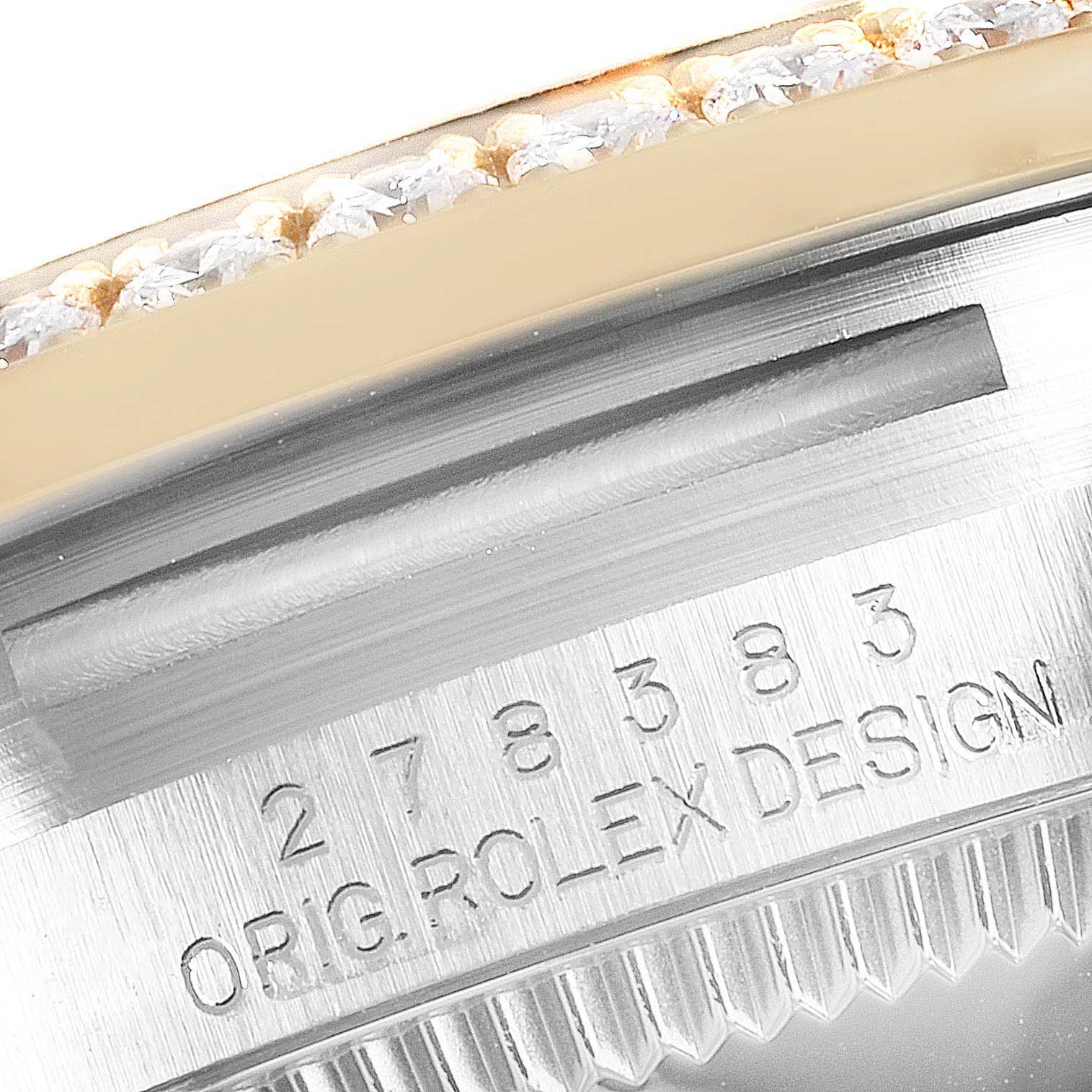 The image shows a close-up of the bezel and case side of a Mid-Size Rolex watch, revealing detailed engravings and gem settings.