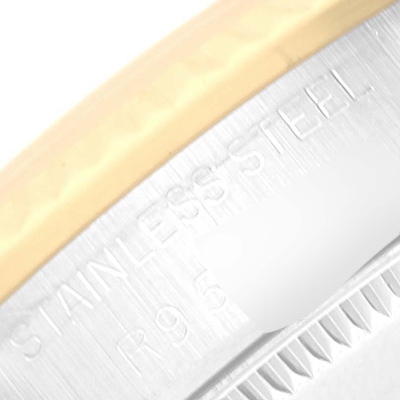 This close-up image of a Rolex Mid-Size 68273 Women
s Steel and Gold (two tone) Champagne Dial 68273 Women
s Steel and Gold (two tone) Champagne Dial model shows the edge of the stainless steel casing with some engraved text.