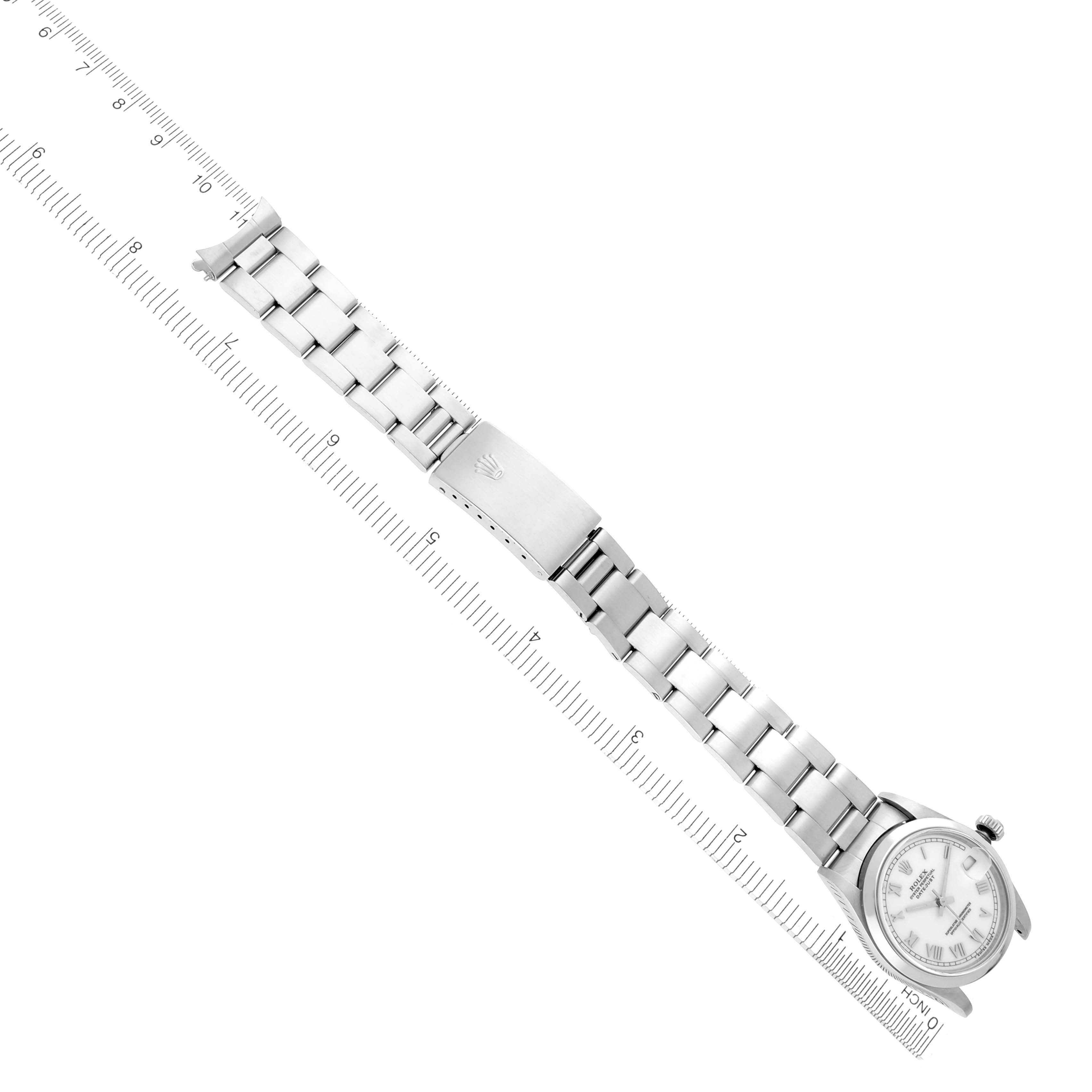 The Rolex Mid-Size 68240 Women
s Stainless Steel White Dial 68240 Women
s Stainless Steel White Dial watch is shown from a top view, displaying the bracelet, clasp, and face aligned with a ruler.