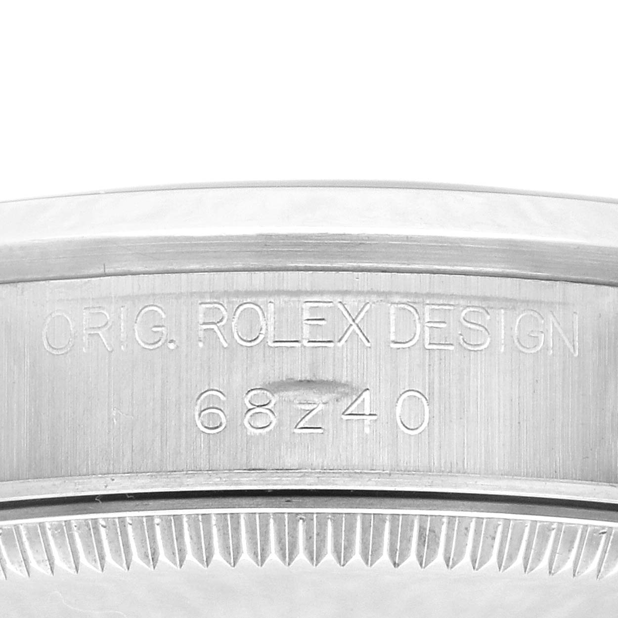 The image shows a close-up of the side of a Rolex Mid-Size 68240 Women
s Stainless Steel White Dial 68240 Women
s Stainless Steel White Dial model, highlighting the engraved serial number and design details.