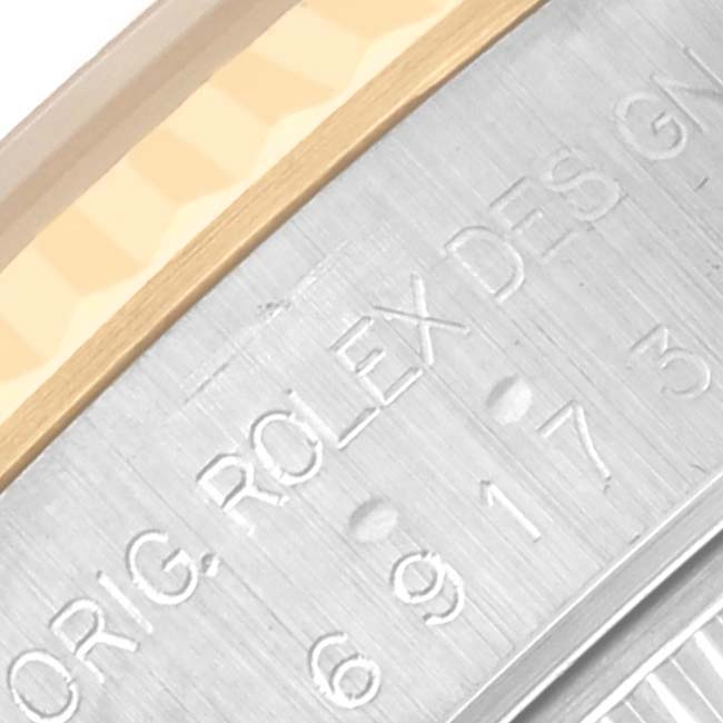 The image shows a close-up of the side of a Rolex Datejust 69173 Women's Steel and Gold (two tone) Silver Dial 69173 Women's Steel and Gold (two tone) Silver Dial, highlighting the engraved text on the casing.