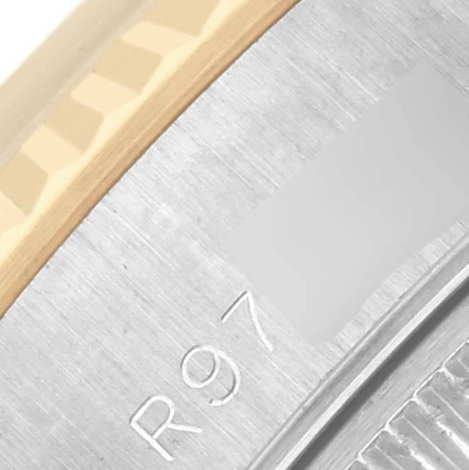 The image shows a close-up of the side of a Rolex Datejust 69173 Women
s Steel and Gold (two tone) Champagne Dial 69173 Women
s Steel and Gold (two tone) Champagne Dial watch, focusing on the fluted bezel and engraved details.