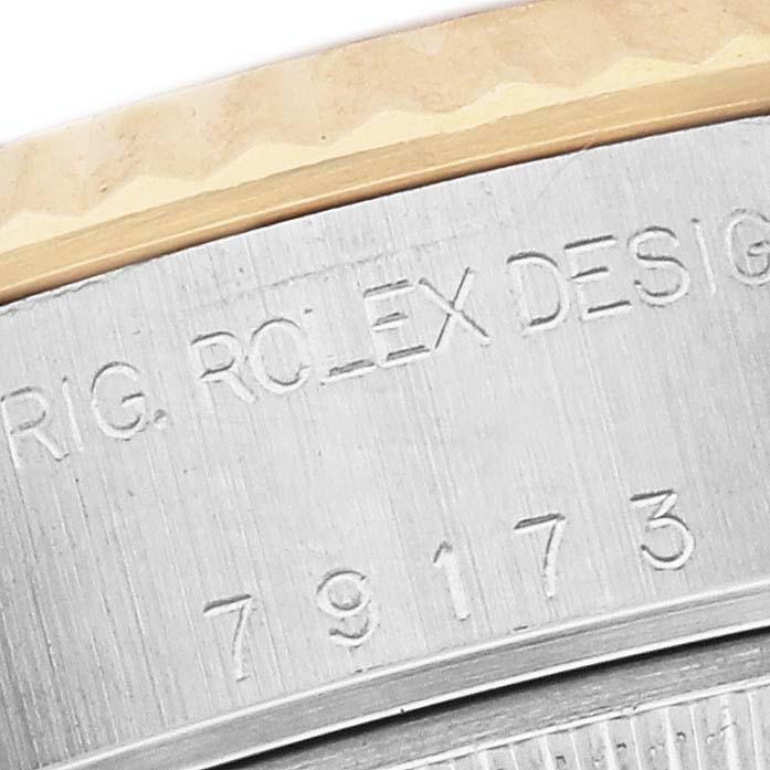 The image shows a close-up of the Rolex Datejust 79173 Women's Steel and Gold (two tone) White Dial 79173 Women's Steel and Gold (two tone) White Dial watch's case side, featuring engravings and the model number.