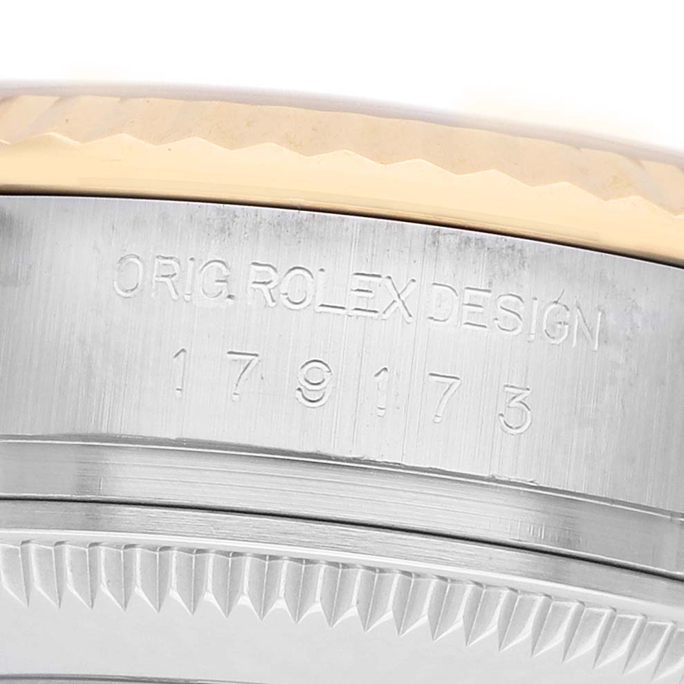 The image shows a close-up of the side of a Rolex Datejust 179173 Women's Stainless Steel White Dial, focusing on the case with "ORIG ROLEX DESIGN" and model number engraving.