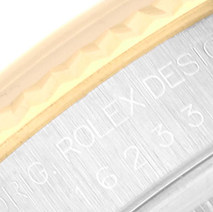 This close-up image of the Rolex Datejust 16233 Men's Steel and Gold (two tone) White Dial 16233 Men's Steel and Gold (two tone) White Dial model shows part of the bezel and the engraved text on the case.