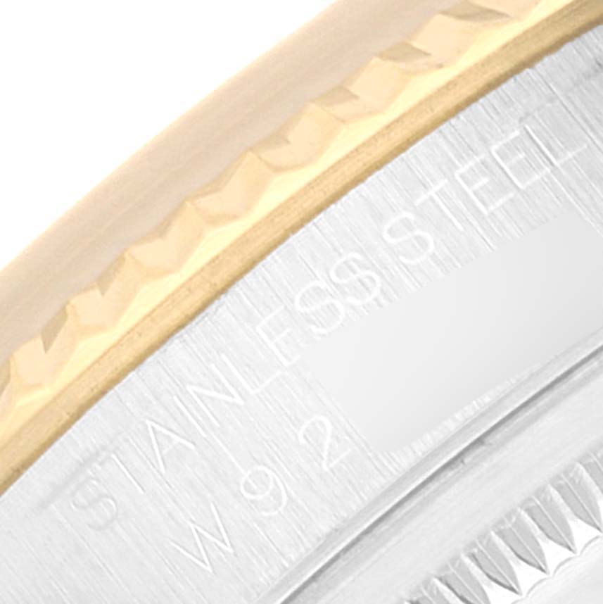 This close-up image of the Rolex Datejust 16233 Men's Steel and Gold (two tone) White Dial 16233 Men's Steel and Gold (two tone) White Dial watch shows the stainless steel case and part of the fluted gold bezel.