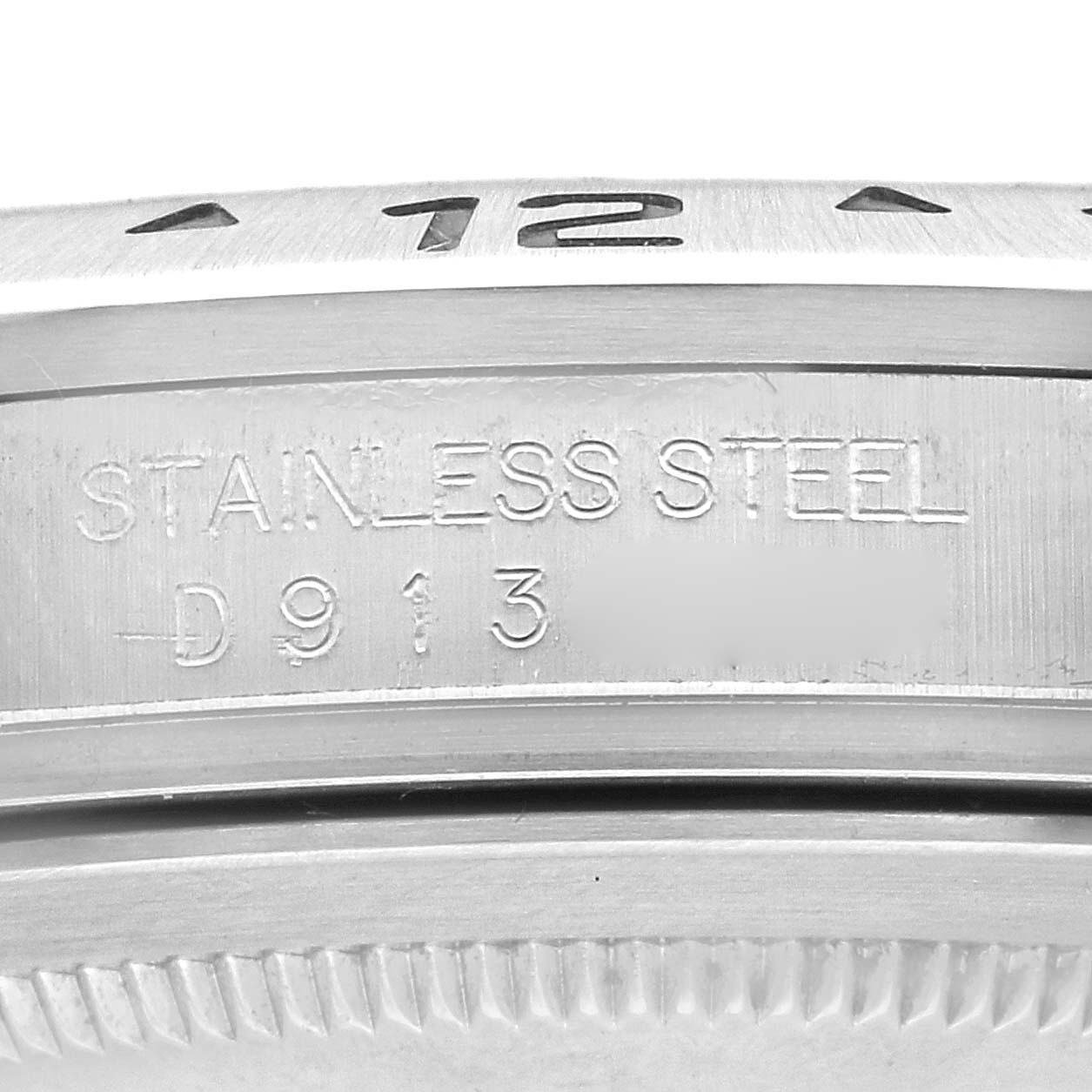 The image shows a close-up of the Rolex Explorer 16570 Men
s Stainless Steel White Dial 16570 Men
s Stainless Steel White Dial
s stainless steel case with etched markings.