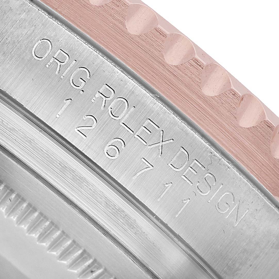 The image shows a close-up of the edge of the Rolex GMT-Master 126711 Men's Steel and Gold (two tone) Black Dial bezel and case side with engraved model details.