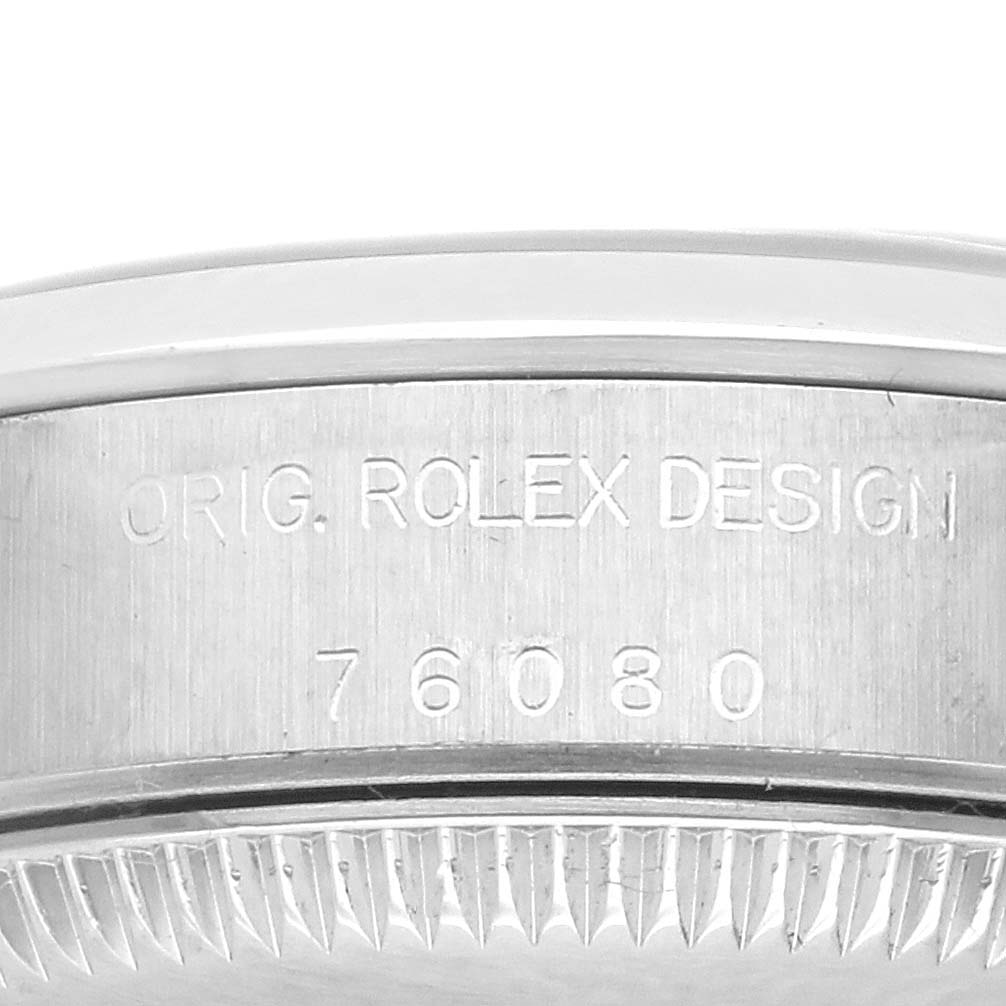 The image shows the side view of a Rolex Oyster Perpetual 76080 Women's Stainless Steel Black Dial 76080 Women's Stainless Steel Black Dial, focusing on the case engraving.