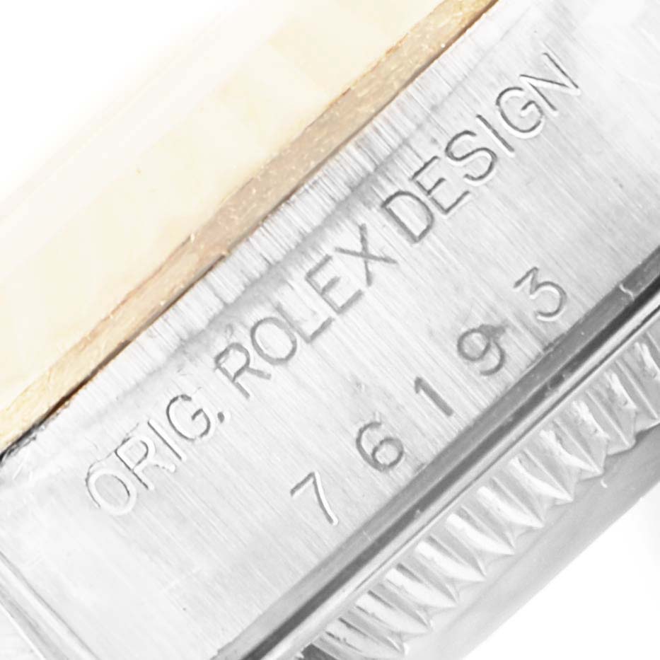 This close-up image shows the side of a Rolex Oyster Perpetual 76193 Women
s Steel and Gold (two tone) Champagne Dial 76193 Women
s Steel and Gold (two tone) Champagne Dial watch case with the model number engraved.