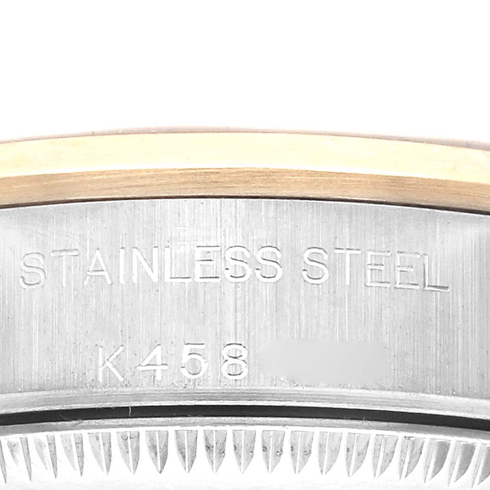 The image shows a close-up of the side of a Rolex Oyster Perpetual 76183 Women's Steel and Gold (two tone) Silver Dial 76183 Women's Steel and Gold (two tone) Silver Dial, highlighting the stainless steel and engravings.