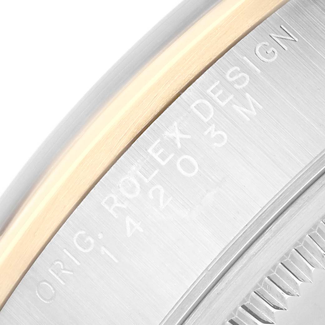 The image shows a close-up of the edge and engraved details of a Rolex Oyster Perpetual 14203 Men's Steel and Gold (two tone) Silver Dial's case.