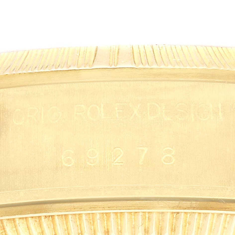 The image shows a close-up of the Rolex President 69278 Women's Yellow Gold Champagne Dial 69278 Women's Yellow Gold Champagne Dial model, focusing on its engraved case side.