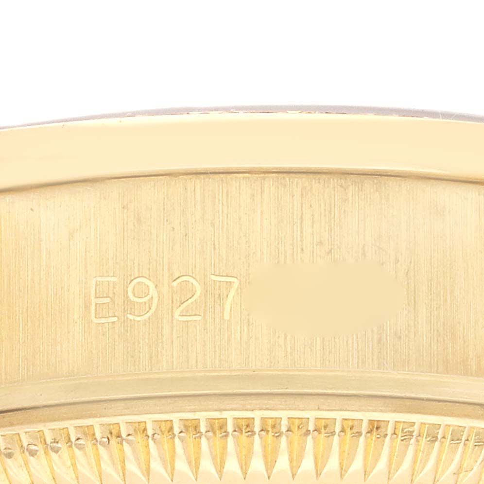 The image shows a close-up of the side case of a Rolex President 69138 Women's Yellow Gold White Dial 69138 Women's Yellow Gold White Dial watch, emphasizing its gold finish and serial number.