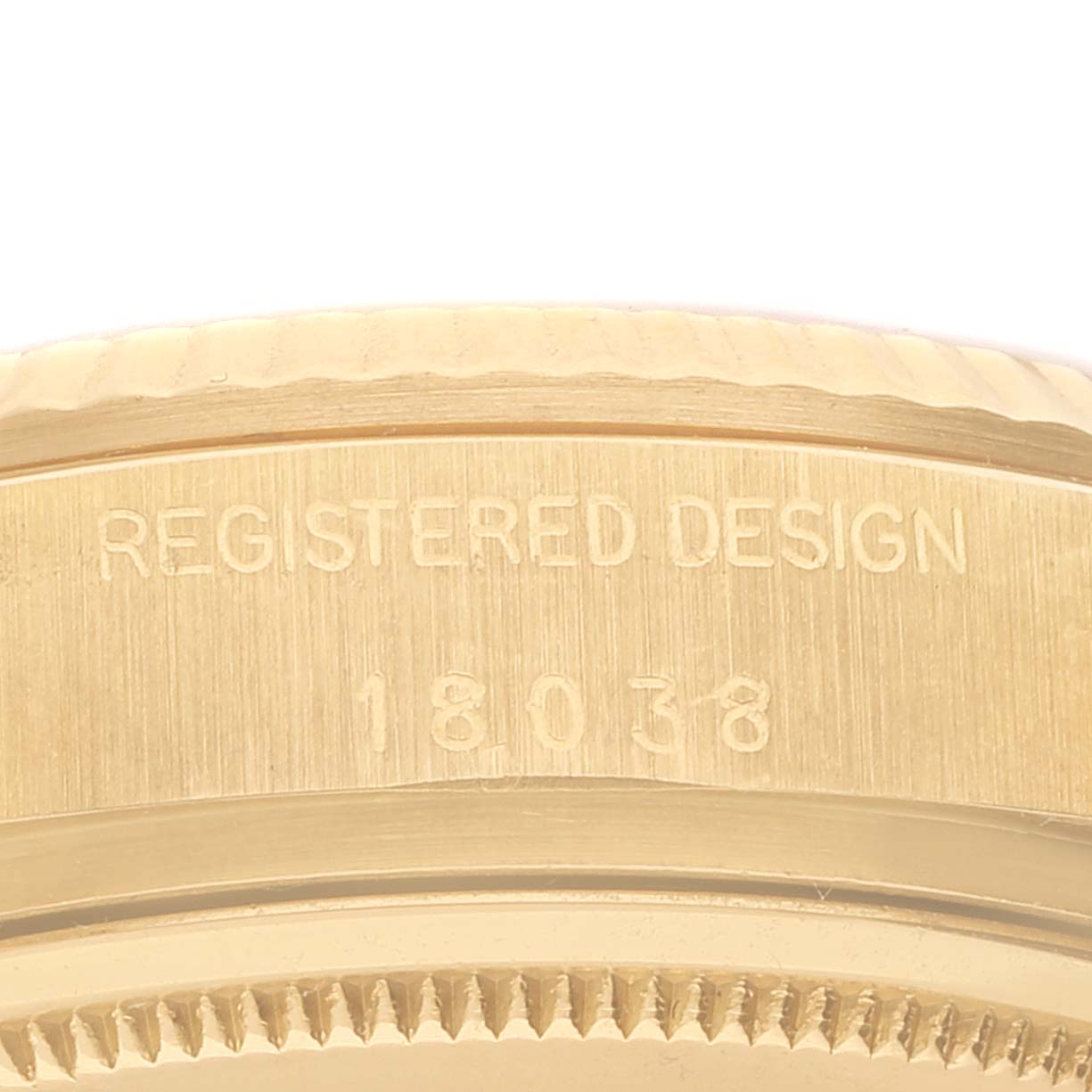 This image shows the side of a Rolex President 18038 Men
s Yellow Gold Champagne Dial 18038 Men
s Yellow Gold Champagne Dial model watch with the registered design and model number 18038 engraved.