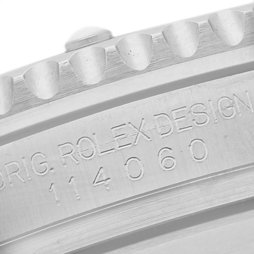 The image shows a close-up of the side engraving and bezel teeth of a Rolex Submariner 114060 Men's Stainless Steel Black Dial 114060 Men's Stainless Steel Black Dial watch.