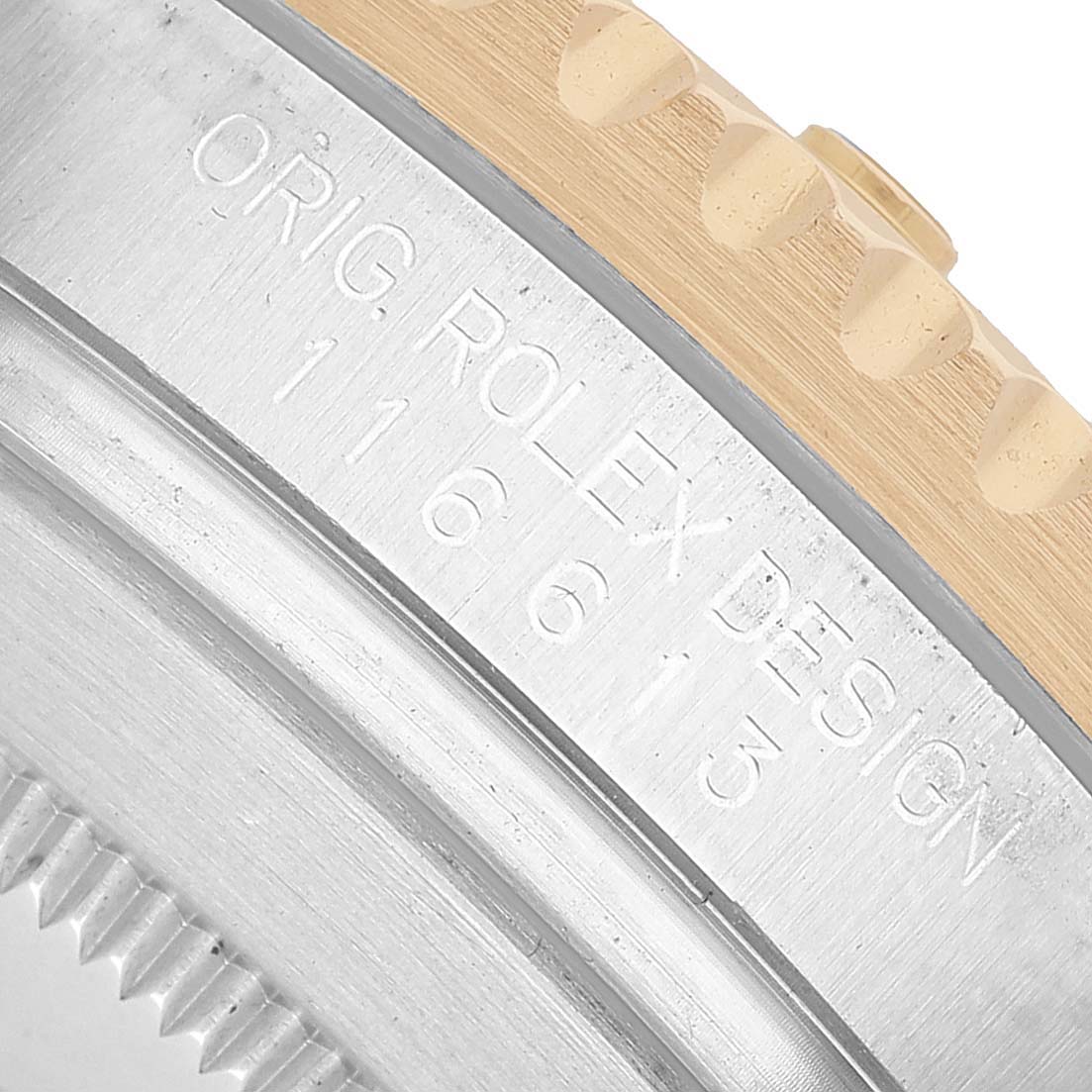 The image shows a close-up of the Rolex Submariner 116613 Men's Stainless Steel Black Dial's case side engraving and a glimpse of the bezel edge.
