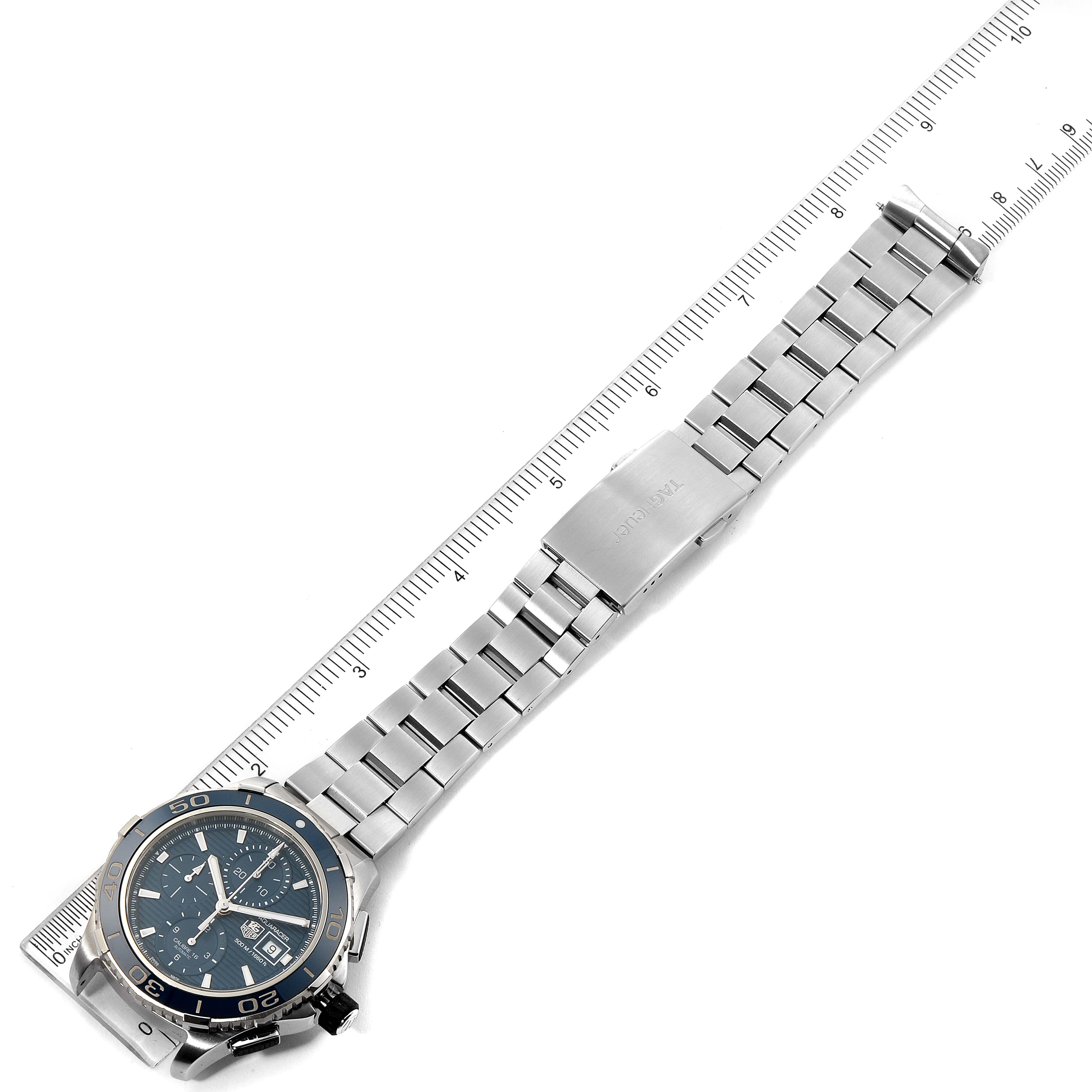The image shows a Tag Heuer Aquaracer CAK2112.BA0833 Men
s Stainless Steel Blue Dial CAK2112.BA0833 Men
s Stainless Steel Blue Dial watch laid flat with a ruler, displaying its face and full metal bracelet.