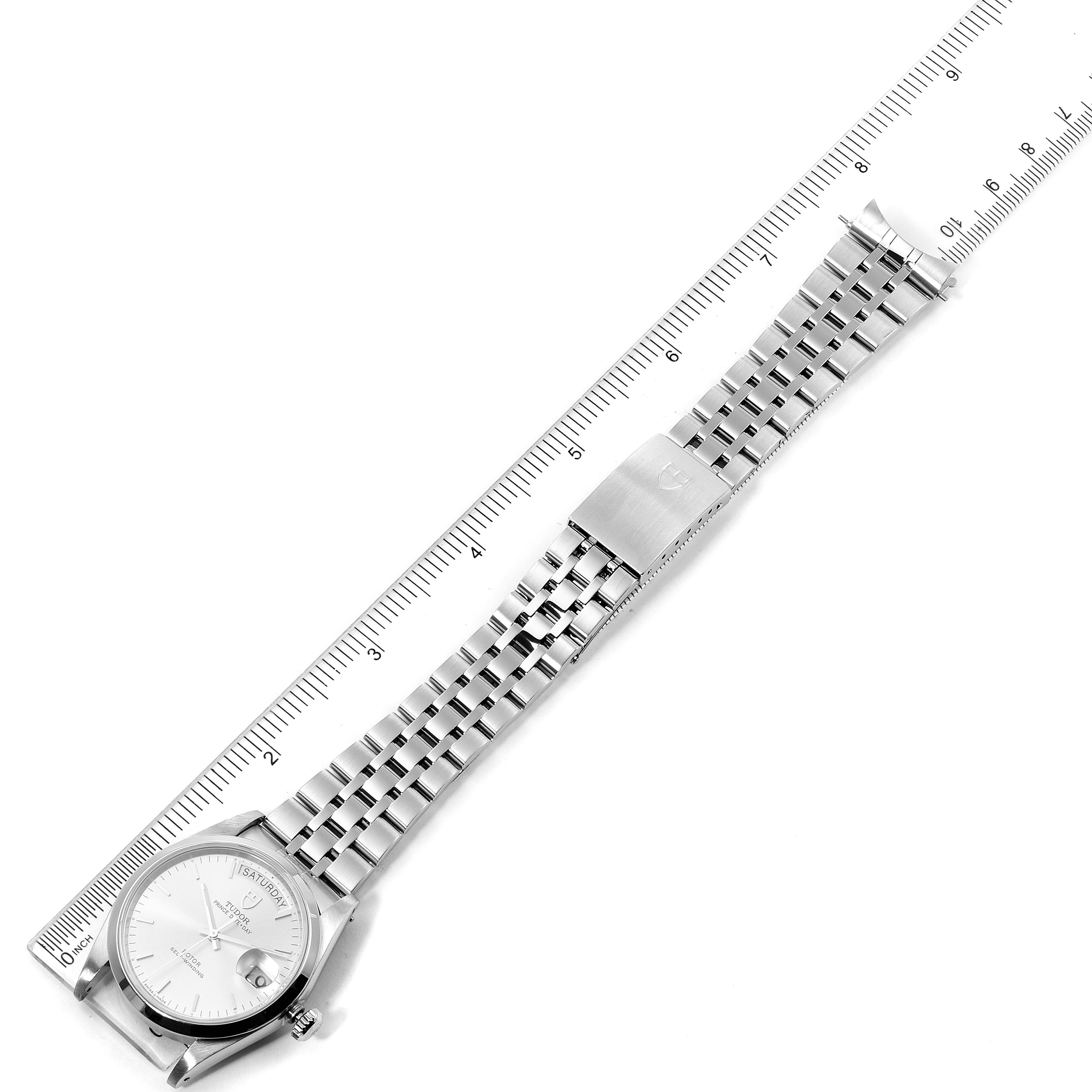 The image shows a Tudor Prince 76200 Men
s Stainless Steel Silver Dial 76200 Men
s Stainless Steel Silver Dial watch laid flat with a stainless steel band, next to a ruler for measurement.