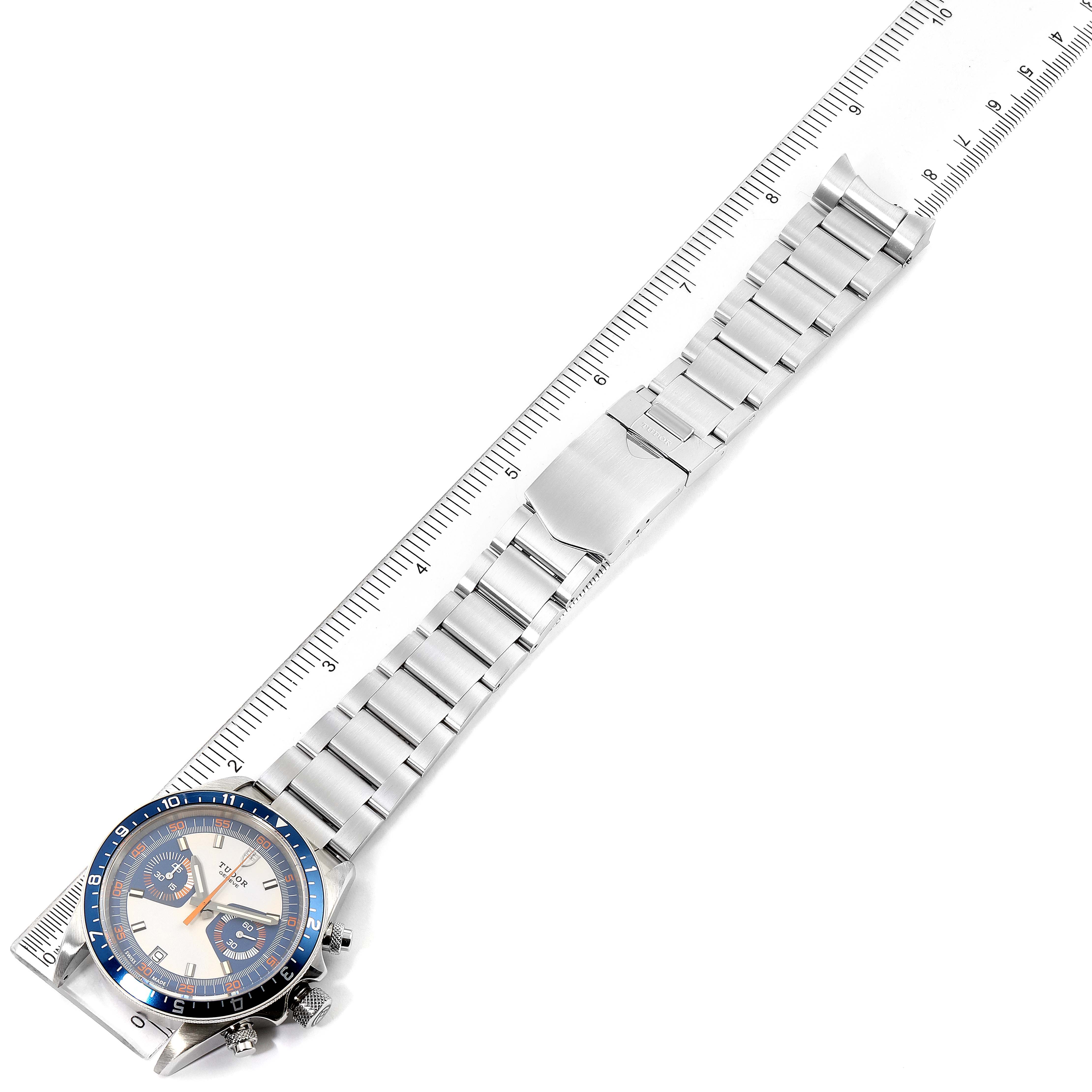 The image shows the Tudor Heritage Chrono 70330B Men's Stainless Steel Blue Dial 70330B Men's Stainless Steel Blue Dial model watch and its metal bracelet laid flat, parallel to a ruler.