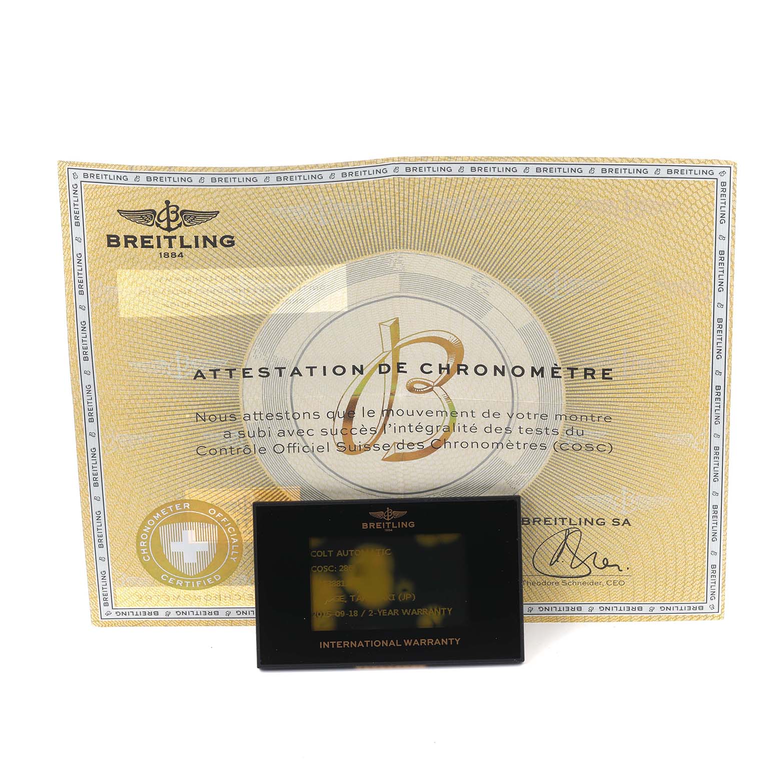 The image shows a Breitling Colt A1738811/BD44 Men's Stainless Steel Black Dial A1738811/BD44 Men's Stainless Steel Black Dial model certification card and warranty against a chronometer attestation certificate.