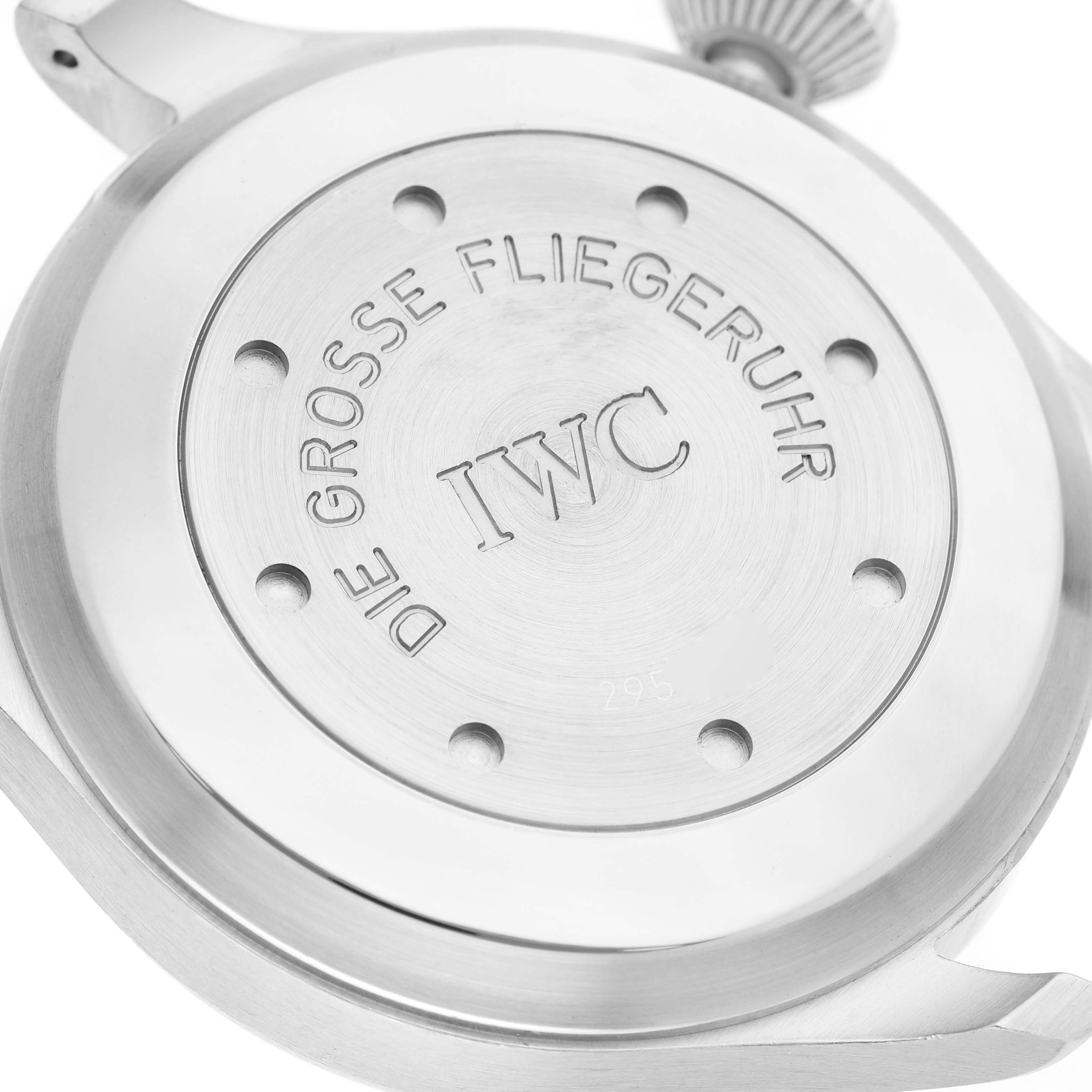 The image shows the back case and crown of an IWC Pilot IW500201 Men's Stainless Steel Black Dial watch, detailing "DIE GROSSE FLIEGERUHR" engraved.