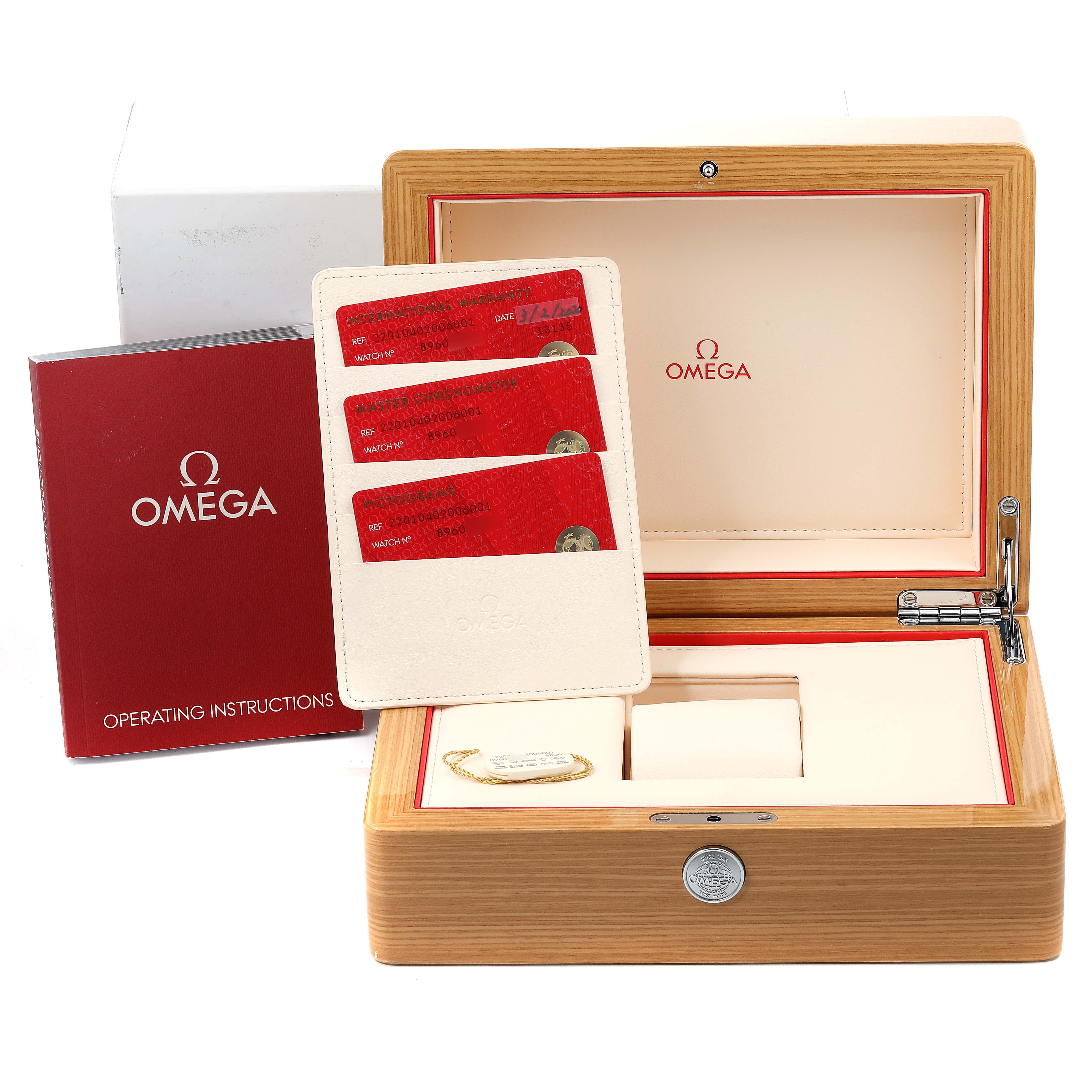 The image shows the Omega Seamaster 220.10.40.20.06.001 Men
s Stainless Steel Grey Dial 220.10.40.20.06.001 Men
s Stainless Steel Grey Dial watch packaging and accessories at an angle, including the box, instruction manual, and warranty cards.
