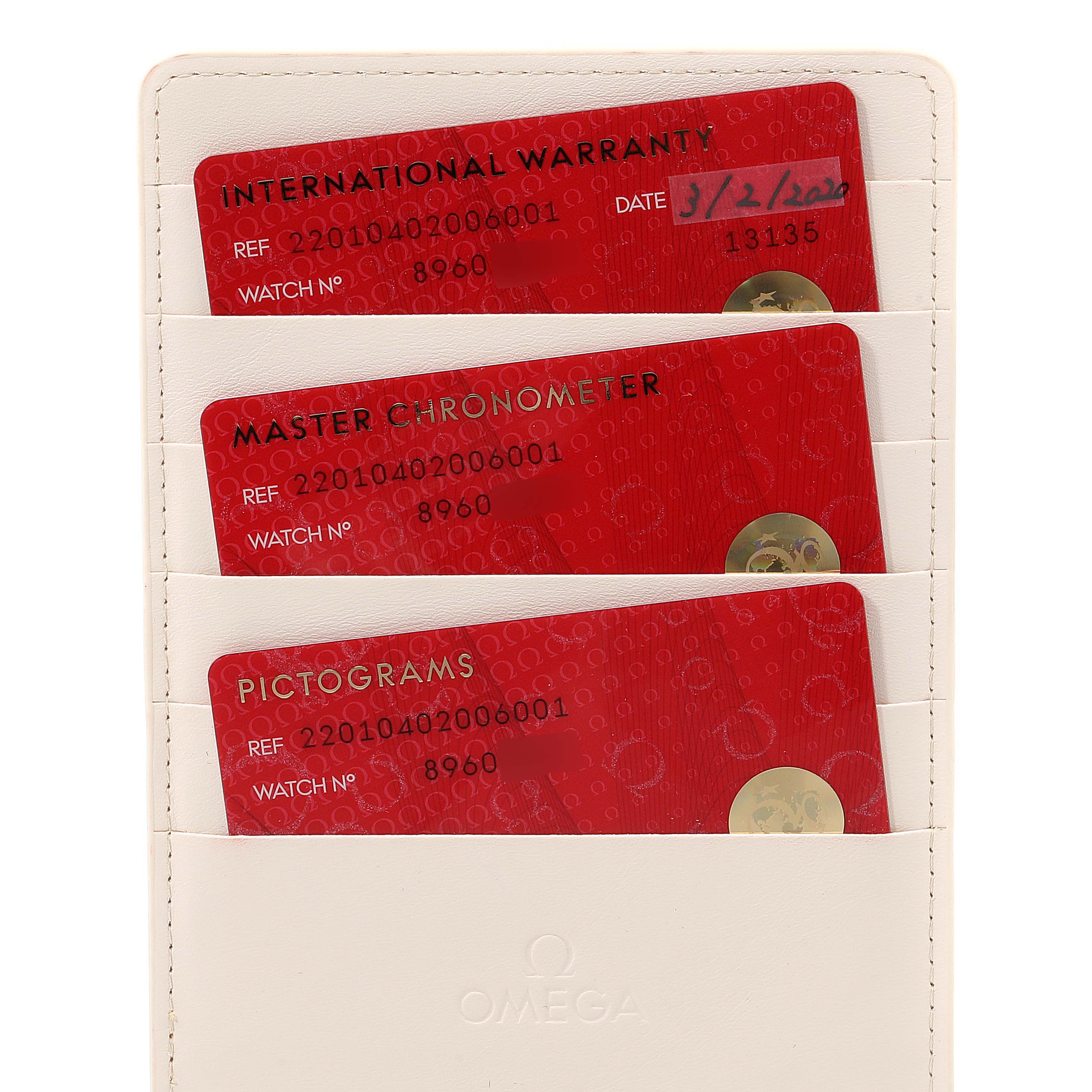 The image shows international warranty, master chronometer, and pictograms cards of an Omega Seamaster 220.10.40.20.06.001 Men
s Stainless Steel Grey Dial 220.10.40.20.06.001 Men
s Stainless Steel Grey Dial watch in a white holder.