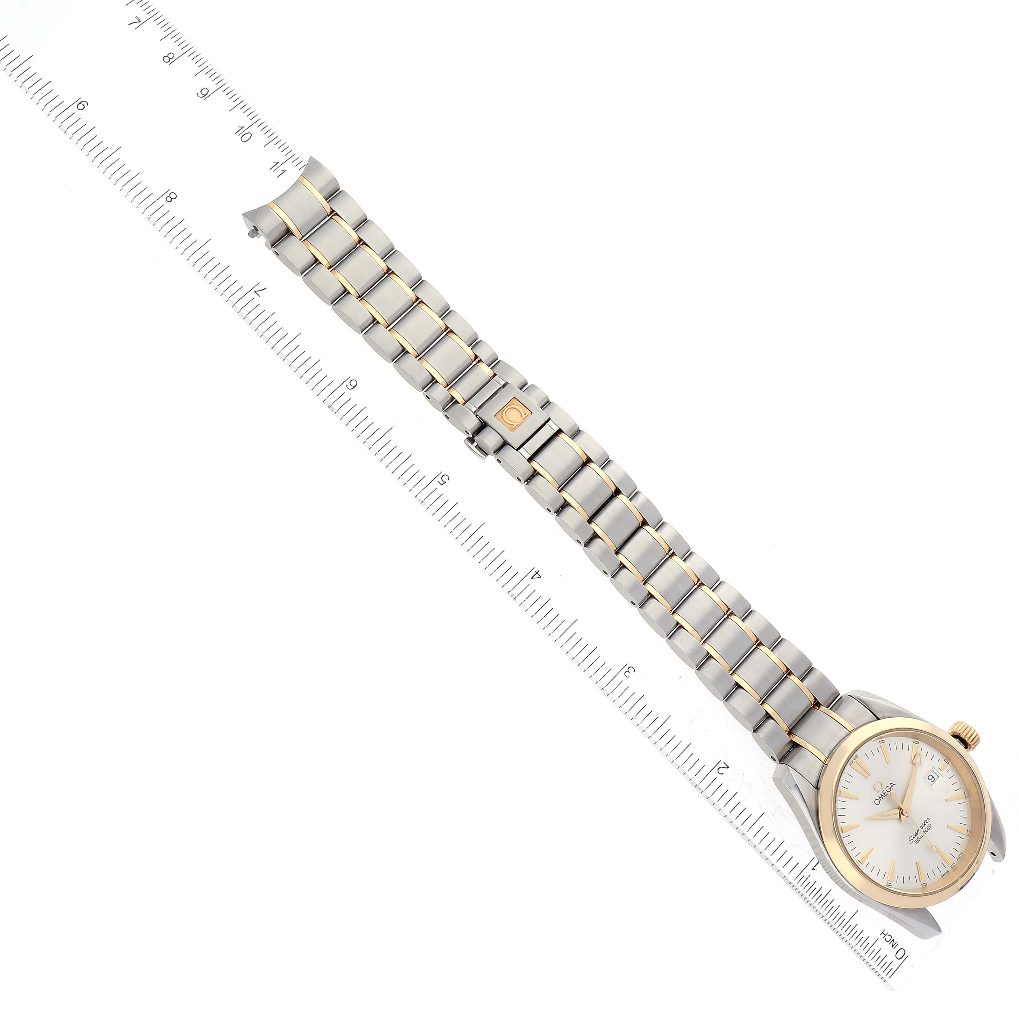 This image shows an Omega Aqua Terra 2318.30.00 Men's Steel and Gold (two tone) Silver Dial 2318.30.00 Men's Steel and Gold (two tone) Silver Dial watch at an angled top-down view with a ruler beside it for scale.