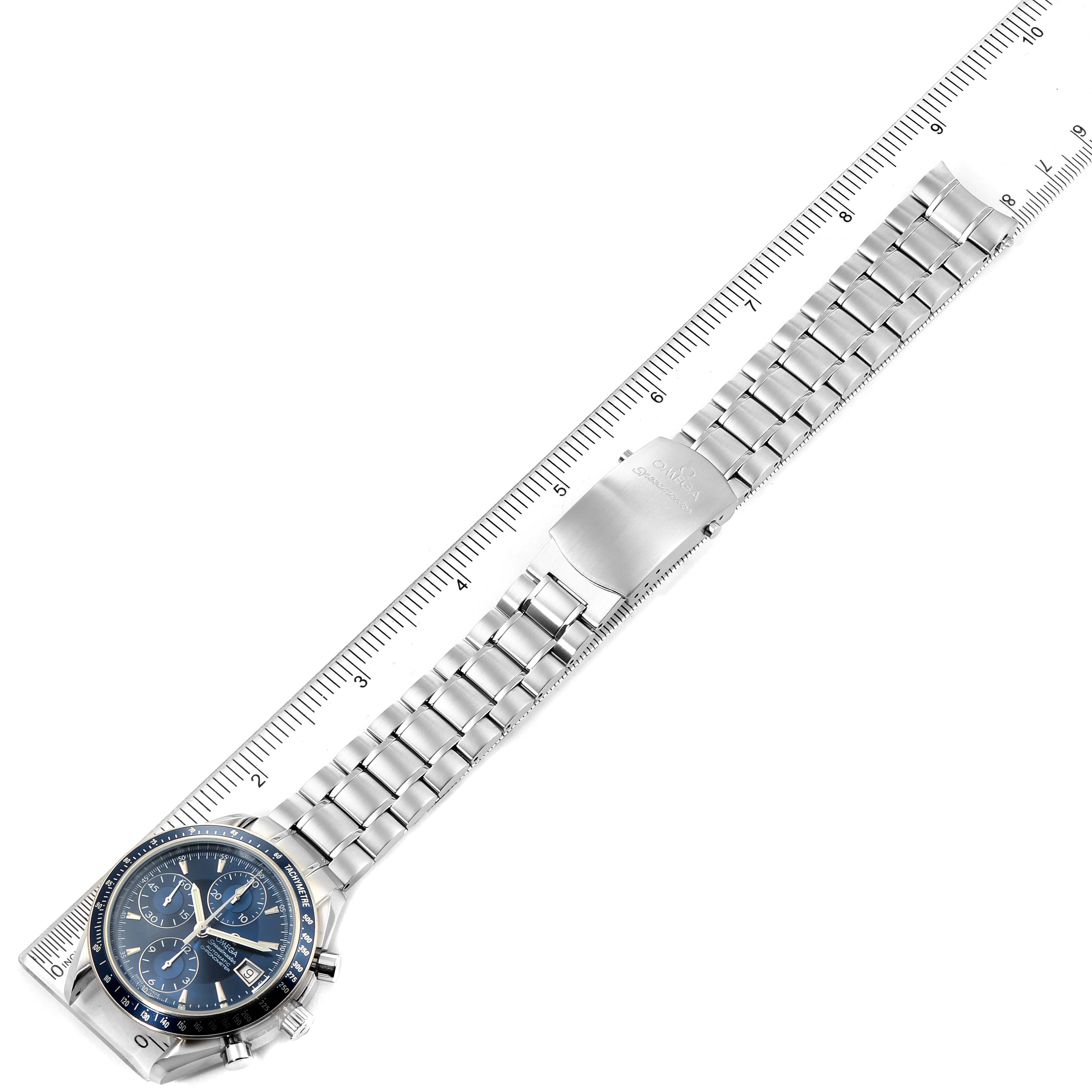 The image shows an Omega Speedmaster 3212.80.00 Men
s Stainless Steel Blue Dial 3212.80.00 Men
s Stainless Steel Blue Dial watch from an aerial perspective, highlighting its full bracelet and clasp alongside a ruler for scale.