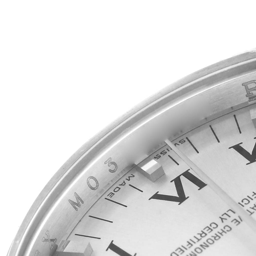 The image shows a close-up of the Date model by Rolex, highlighting the bezel and partial dial with Roman numerals.