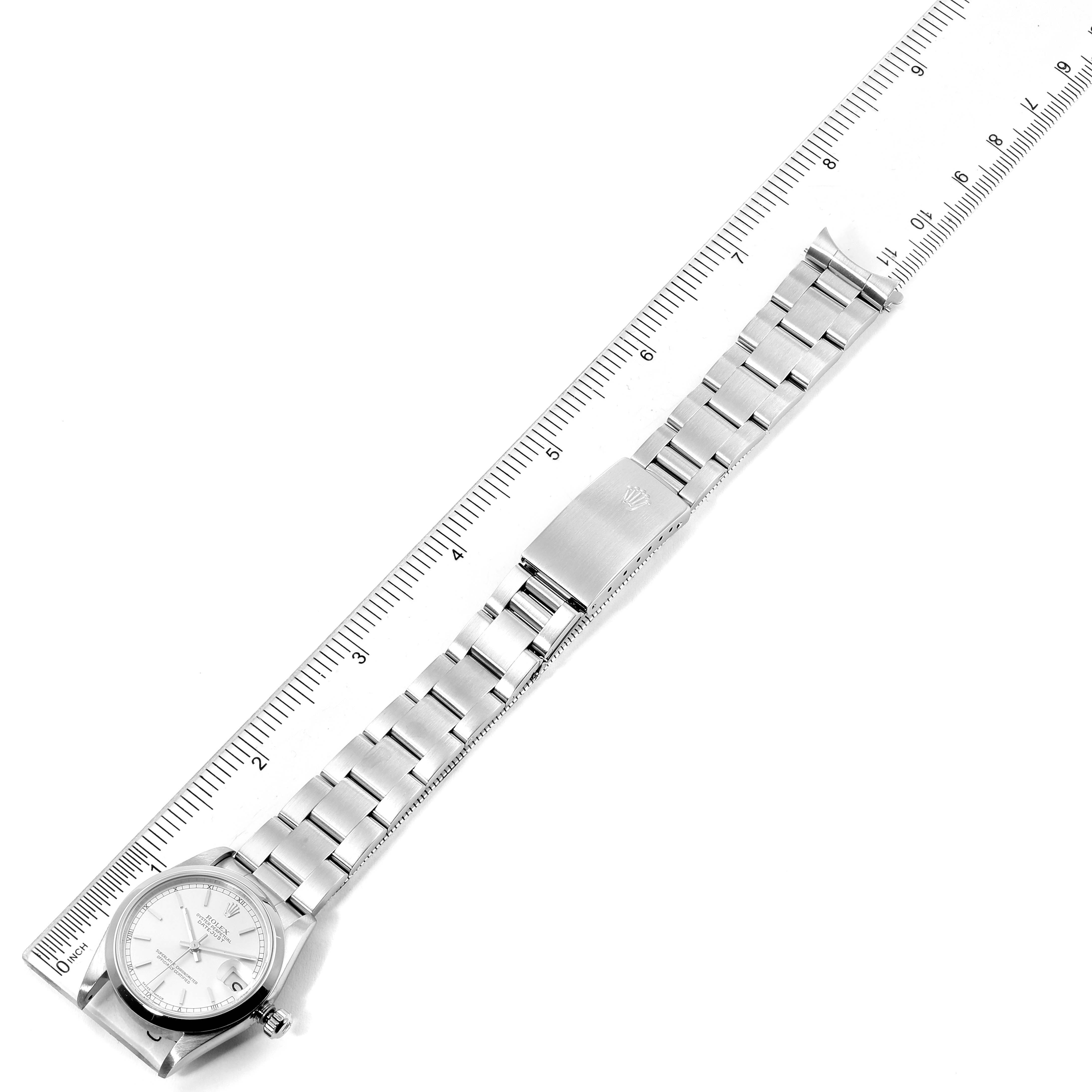 The image shows a Rolex Mid-Size 78240 Women
s Stainless Steel Silver Dial 78240 Women
s Stainless Steel Silver Dial watch laid flat with its band and clasp fully visible against a ruler.