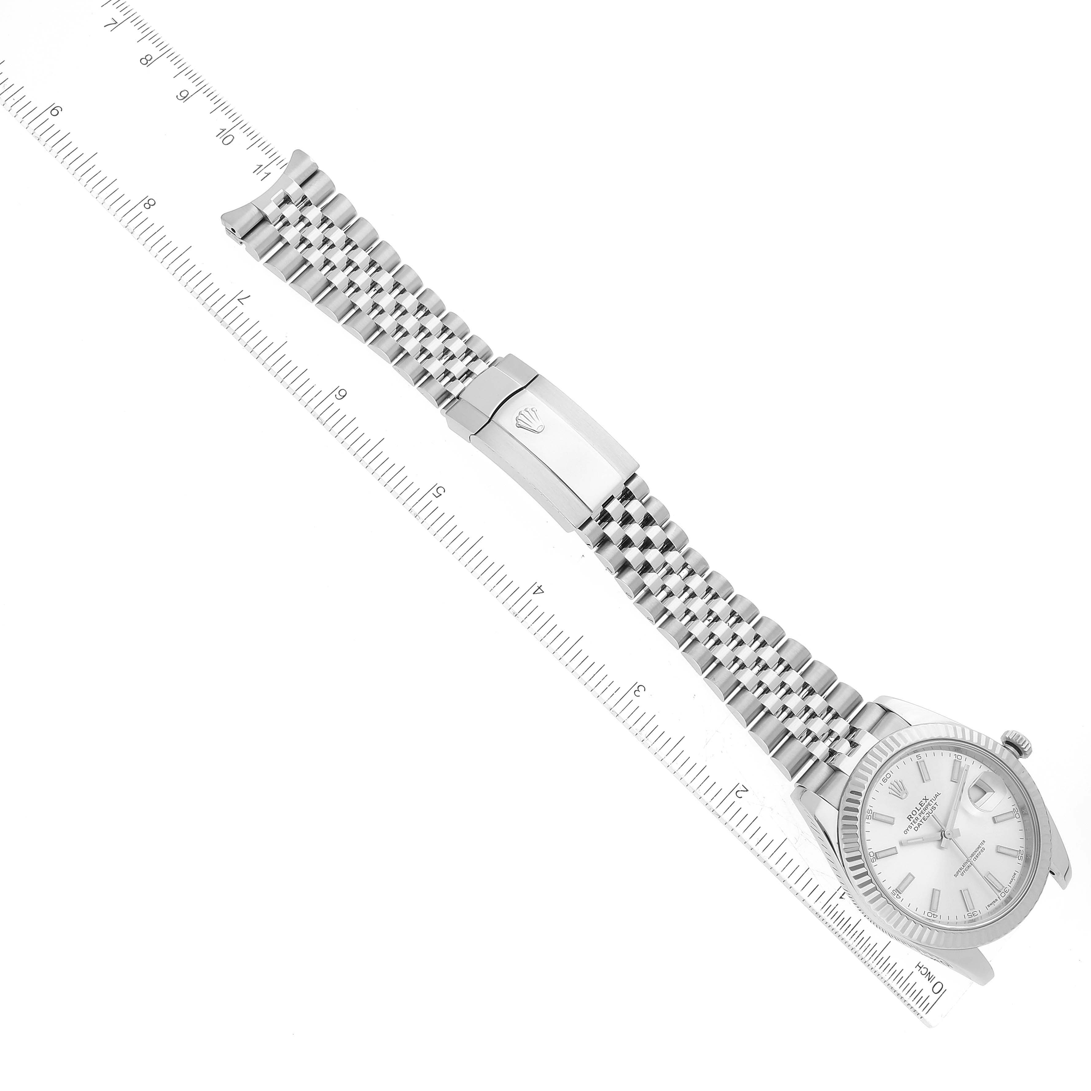 This image shows a top-down view of a Rolex Datejust 41 126334 Men
s Stainless Steel Silver Dial 126334 Men
s Stainless Steel Silver Dial watch with the full watch and its bracelet extended alongside a ruler.