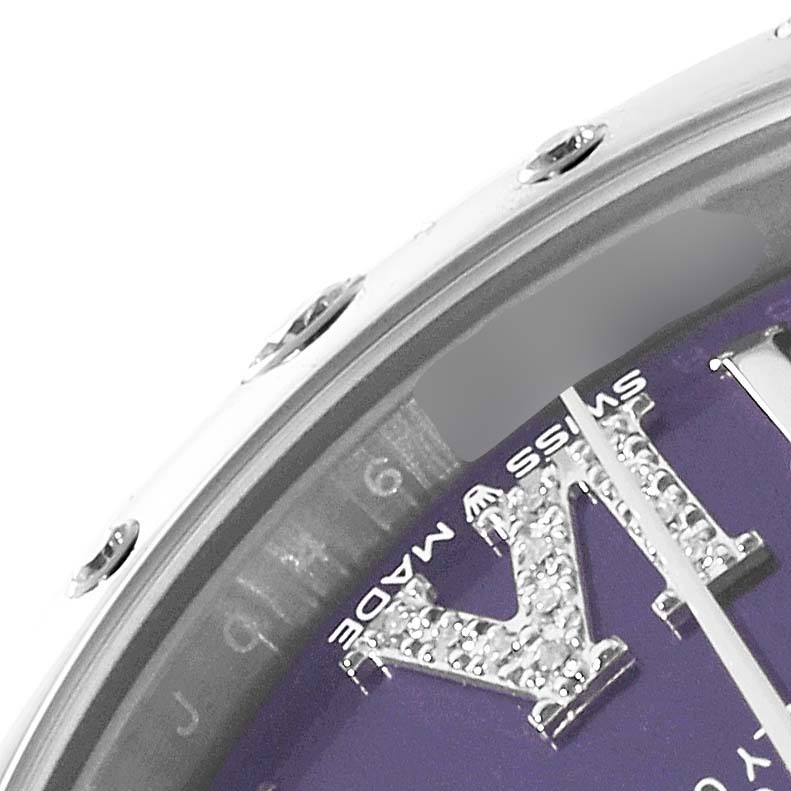 The image shows a close-up of the bezel and a part of the dial on a Mid-Size Rolex watch, focusing on the markings and some diamonds on the dial.