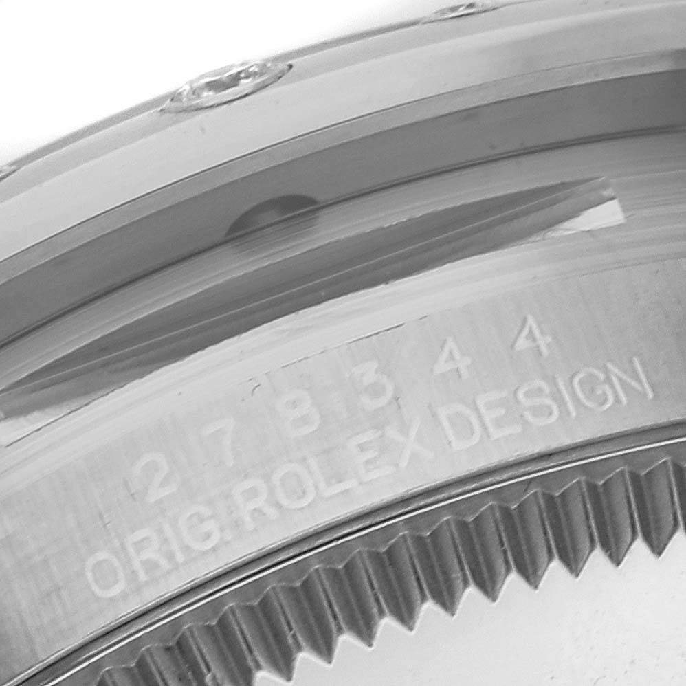 This close-up angle shows the engraved bezel and part of the edge of a Mid-Size Rolex watch with "ORIG.ROLEX DESIGN" visible.