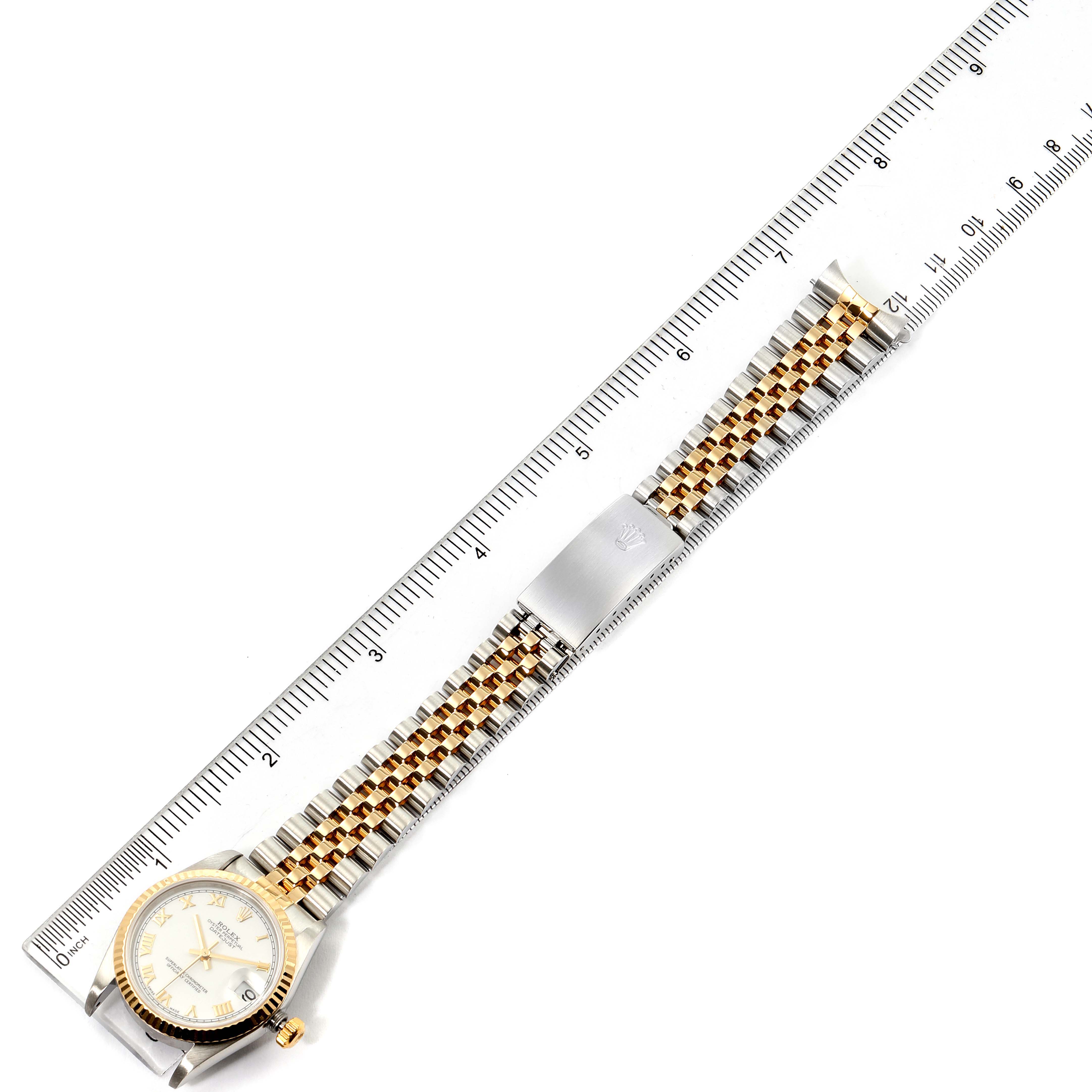 The Rolex Mid-Size 78273 Women
s Steel and Gold (two tone) White Dial 78273 Women
s Steel and Gold (two tone) White Dial watch is shown from a top-down angle, featuring the face, bezel, and band with a ruler for scale.
