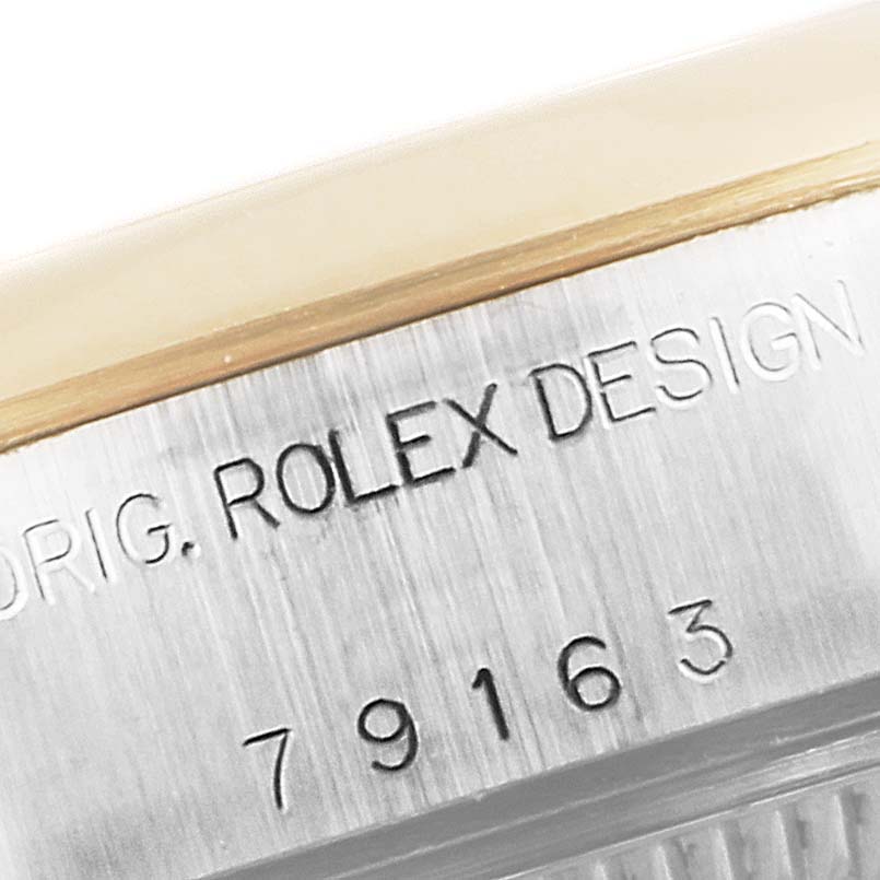 This close-up of a Rolex Datejust 79163 Women's Steel and Gold (two tone) Champagne Dial 79163 Women's Steel and Gold (two tone) Champagne Dial shows the engraved model number and "Rolex Design" inscription on the case edge.