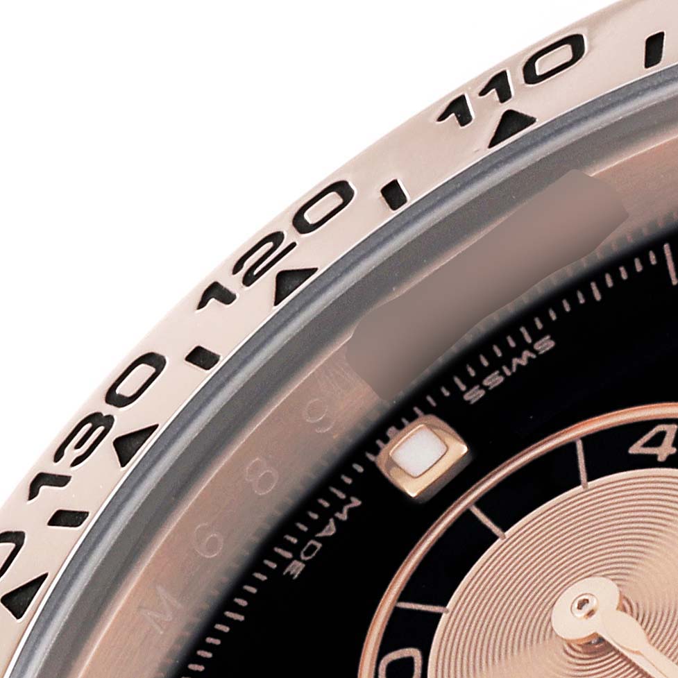 This image shows a close-up of the bezel and part of the dial of a Rolex Daytona 116505 Men's Rose Gold Black Dial 116505 Men's Rose Gold Black Dial watch.