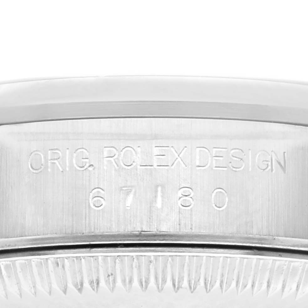 The image shows the side of the Rolex Oyster Perpetual 67180 Women's Stainless Steel Black Dial 67180 Women's Stainless Steel Black Dial watch with the model number "67180" and "ORIG. ROLEX DESIGN" engraved.