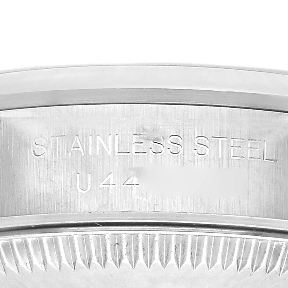 The image shows a close-up of the side engraving on a Rolex Oyster Perpetual 67180 Women's Stainless Steel Black Dial 67180 Women's Stainless Steel Black Dial watch, focusing on "STAINLESS STEEL" text.