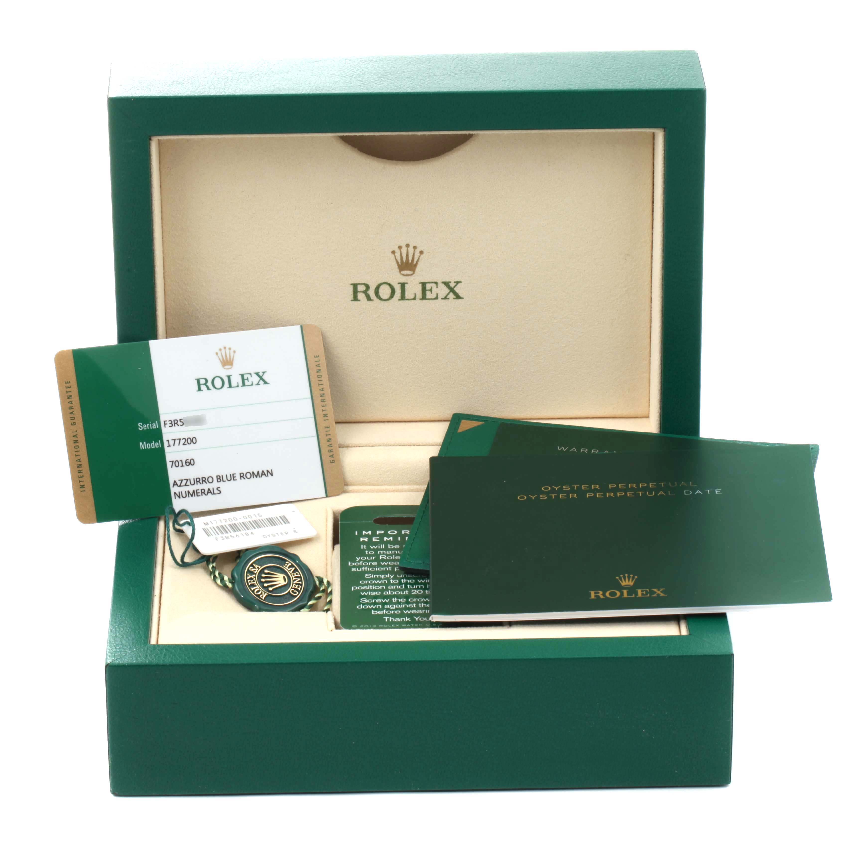The image shows a Rolex Mid-Size 177200 Women
s Stainless Steel Blue Dial 177200 Women
s Stainless Steel Blue Dial model watch box with its accessories, including warranty cards, a tag, and a booklet.