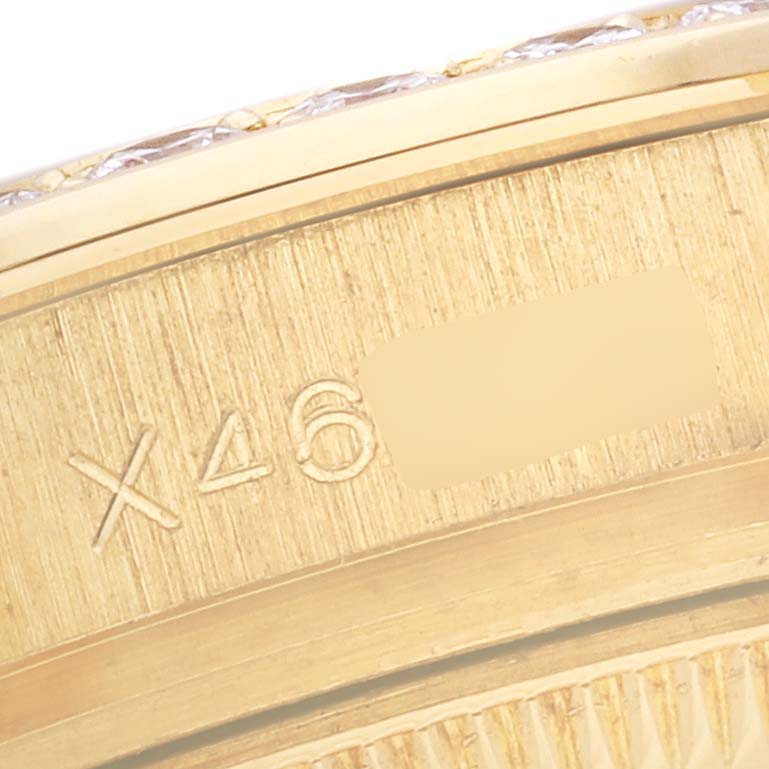The image shows a close-up of the side of a Rolex Pearlmaster 69298 Women
s Yellow Gold Champagne Dial 69298 Women
s Yellow Gold Champagne Dial watch, focusing on the engraved details on the gold bezel.