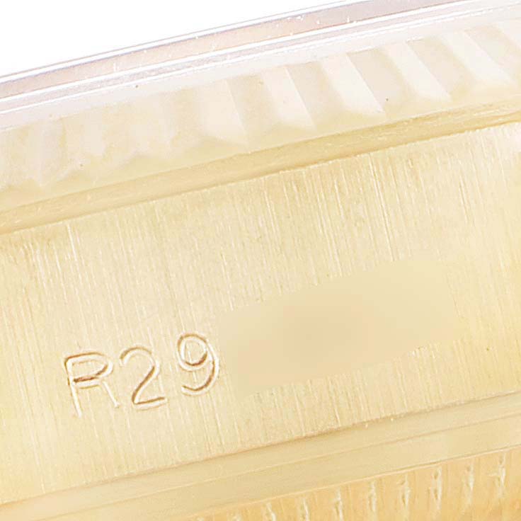 This close-up image of the Rolex President 69178 Women
s Yellow Gold Champagne Dial 69178 Women
s Yellow Gold Champagne Dial watch shows part of the bezel and an engraved serial number.