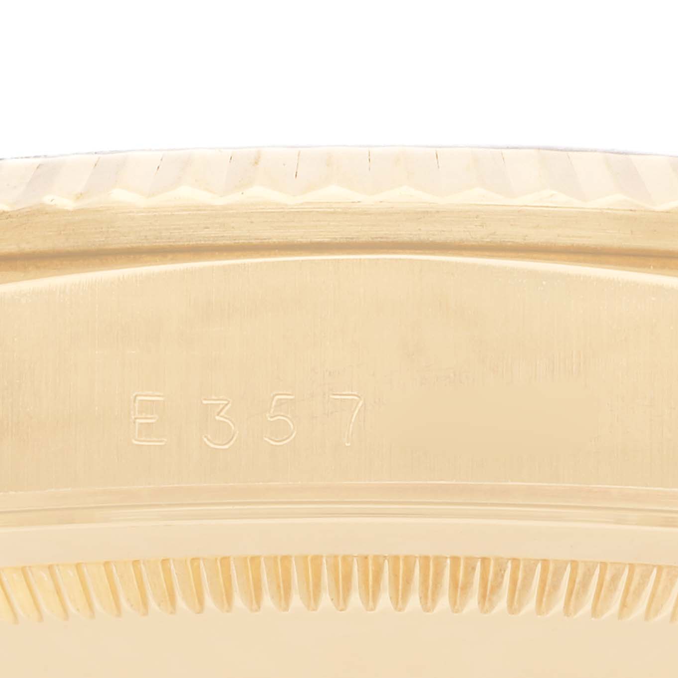 The image shows a close-up of the side of a Rolex President 18238 Men
s Yellow Gold Champagne Dial 18238 Men
s Yellow Gold Champagne Dial watch, highlighting its fluted bezel and part of its serial number "E357".