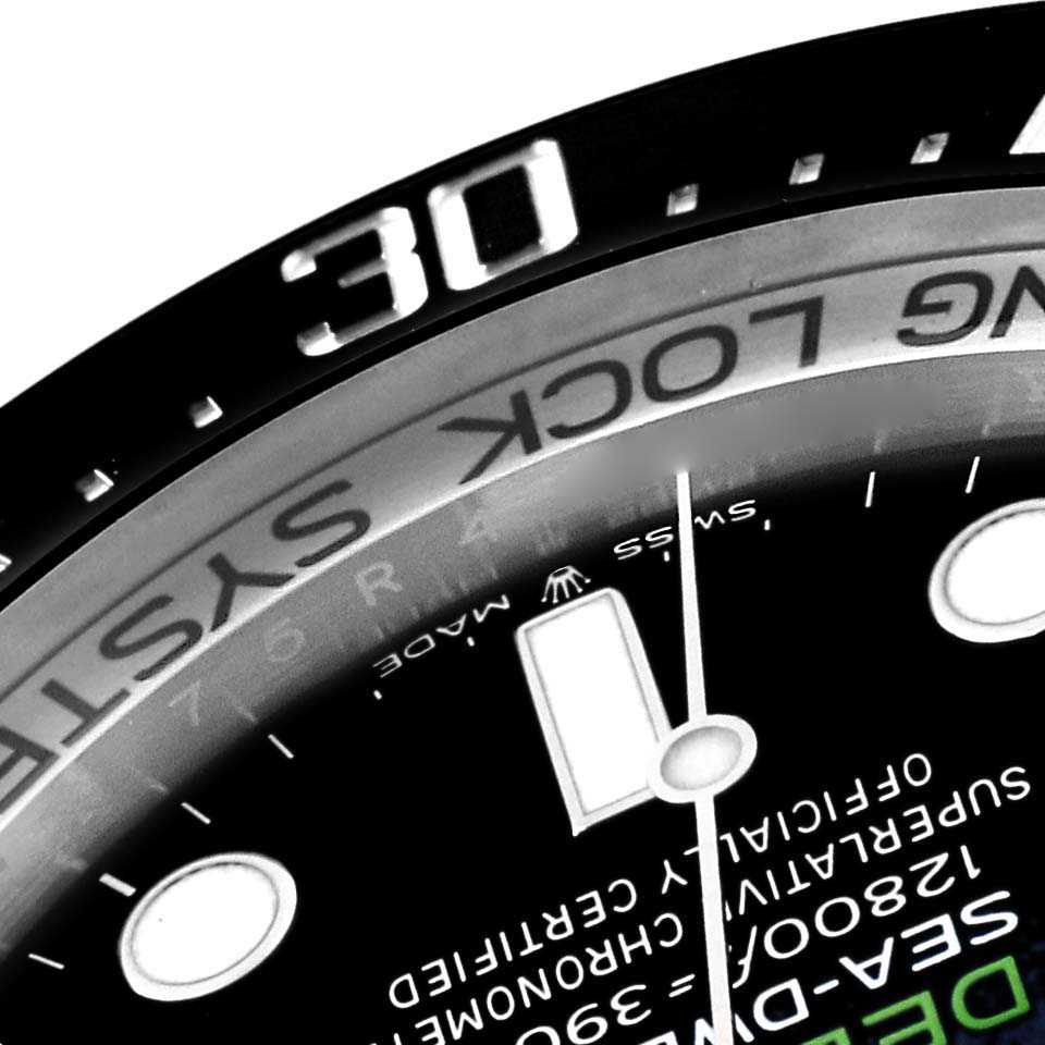 This close-up image of the Rolex Sea-Dweller 126660 Men's Stainless Steel Blue Dial 126660 Men's Stainless Steel Blue Dial shows part of the bezel, the dial, and the minute hand.