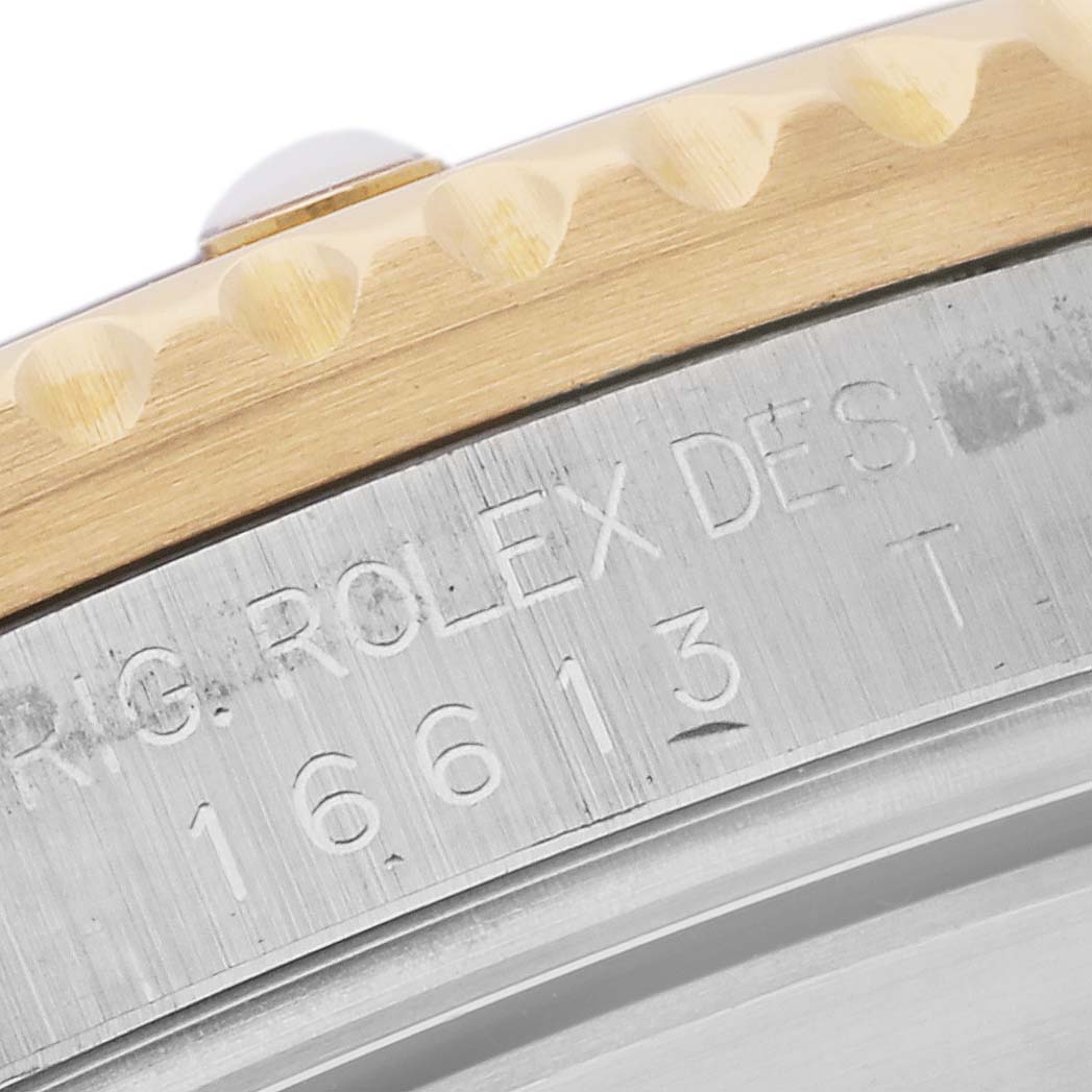 The image shows a close-up of the side edge of a Rolex Submariner 16613 Men's Steel and Gold (two tone) Grey Dial 16613 Men's Steel and Gold (two tone) Grey Dial model, highlighting the bezel and case engraving.
