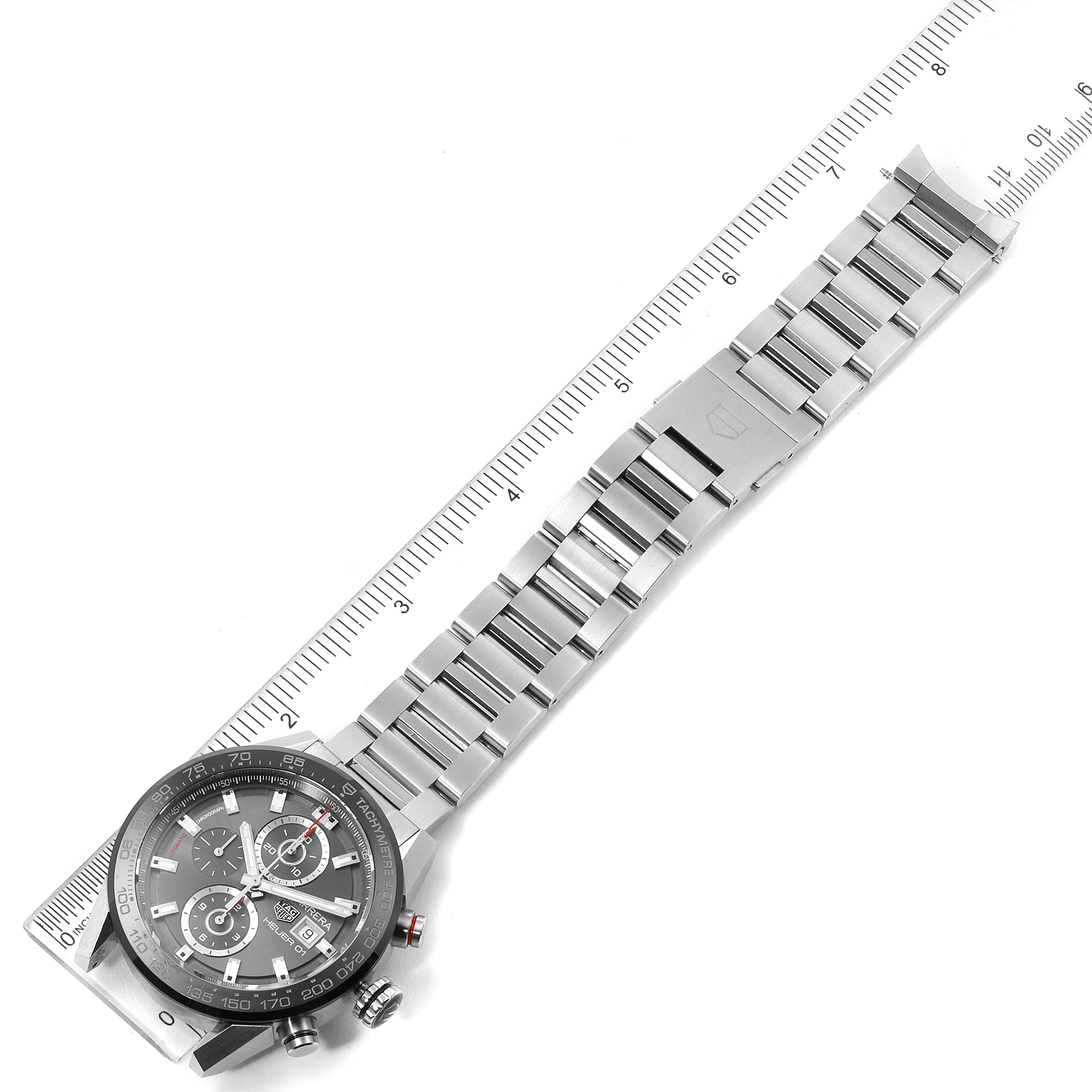 The Tag Heuer Carrera CAR201W.BA0714 Men
s Stainless Steel Black Dial CAR201W.BA0714 Men
s Stainless Steel Black Dial watch is shown from an overhead angle, displaying the face and stainless steel watch band next to a ruler.