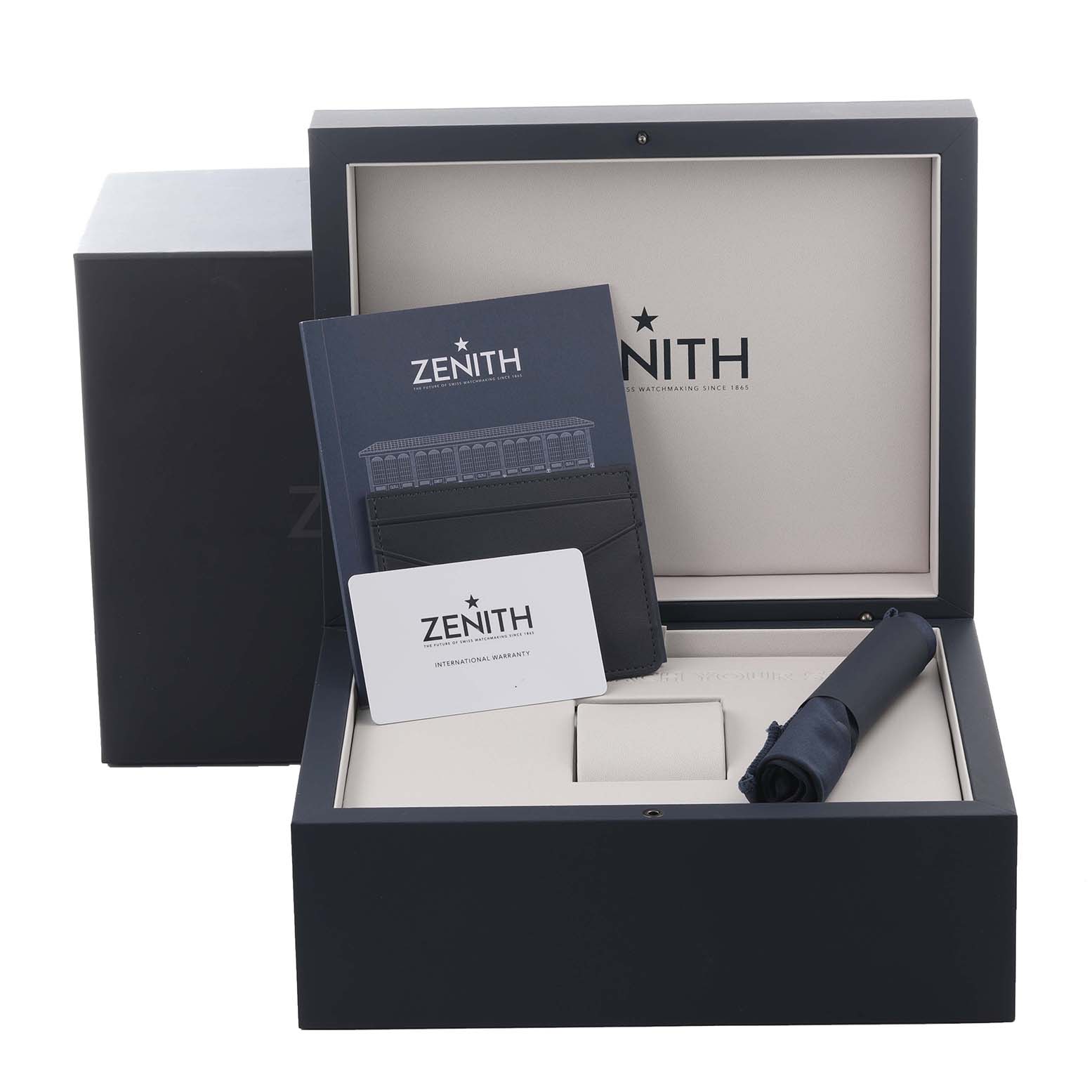 The image shows an open box for the Zenith Chronomaster 03.3106.3600/55.M3100 Men's Stainless Steel Blue Dial 03.3106.3600/55.M3100 Men's Stainless Steel Blue Dial, showcasing a booklet, warranty card, and watch holder.