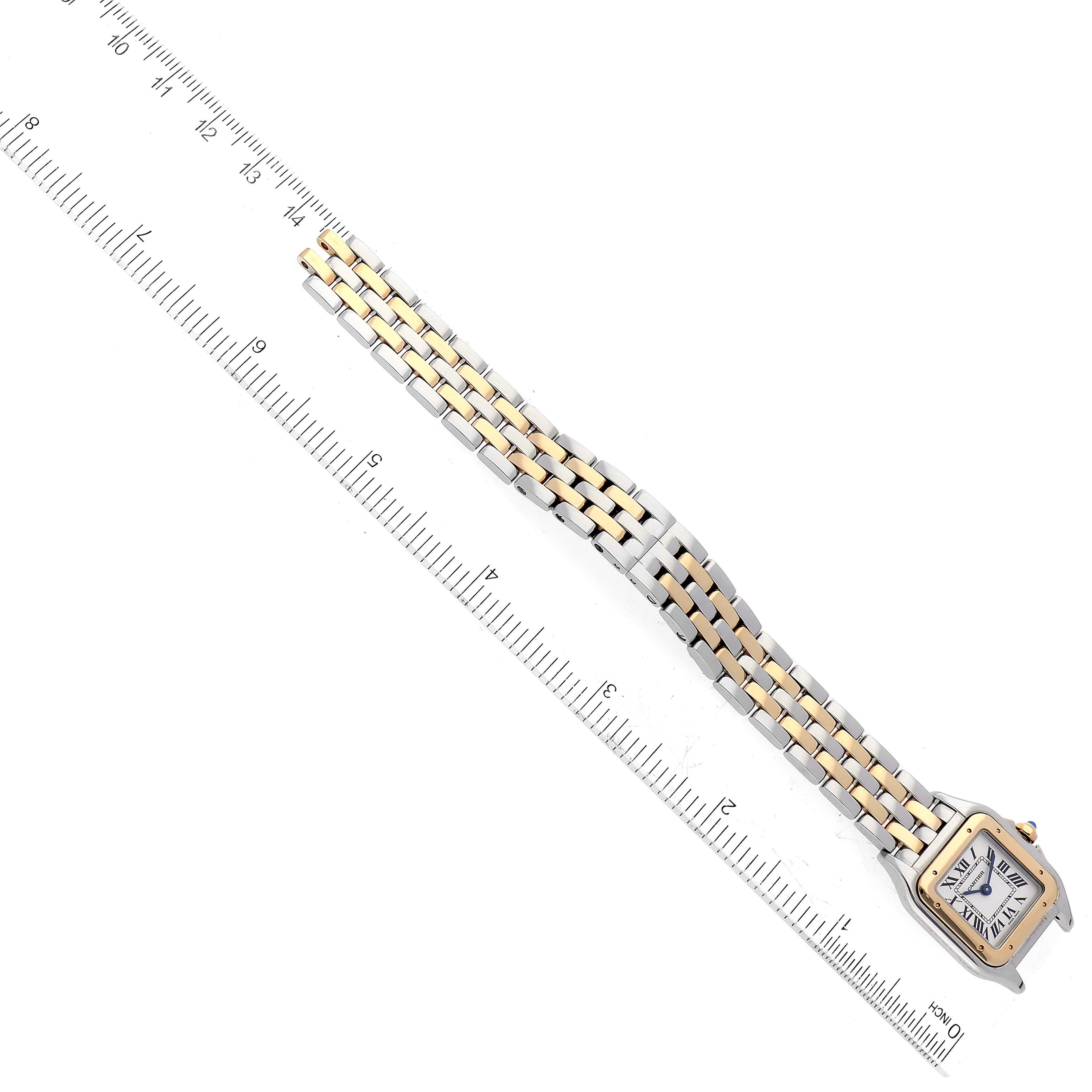 The Panthere de Cartier watch is shown from an overhead angle, displaying its face, bezel, and two-tone bracelet alongside a ruler.